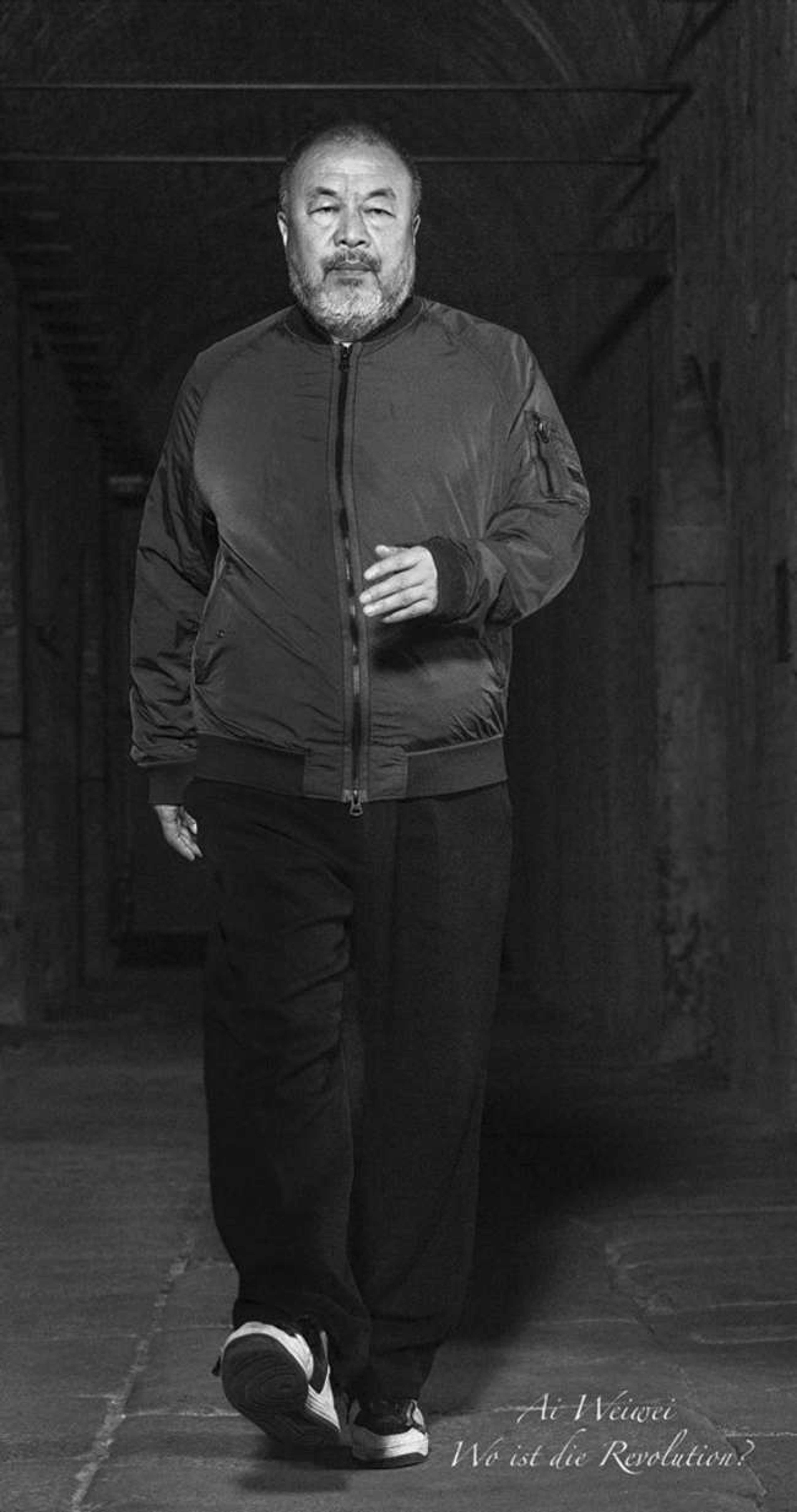 Wo Ist Die Revolution d'Ai Weiwei (2019). Un portrait en noir et blanc de l'artiste marchant vers l'objectif, sur lequel est superposé le texte « Wo ist die revolution? ».