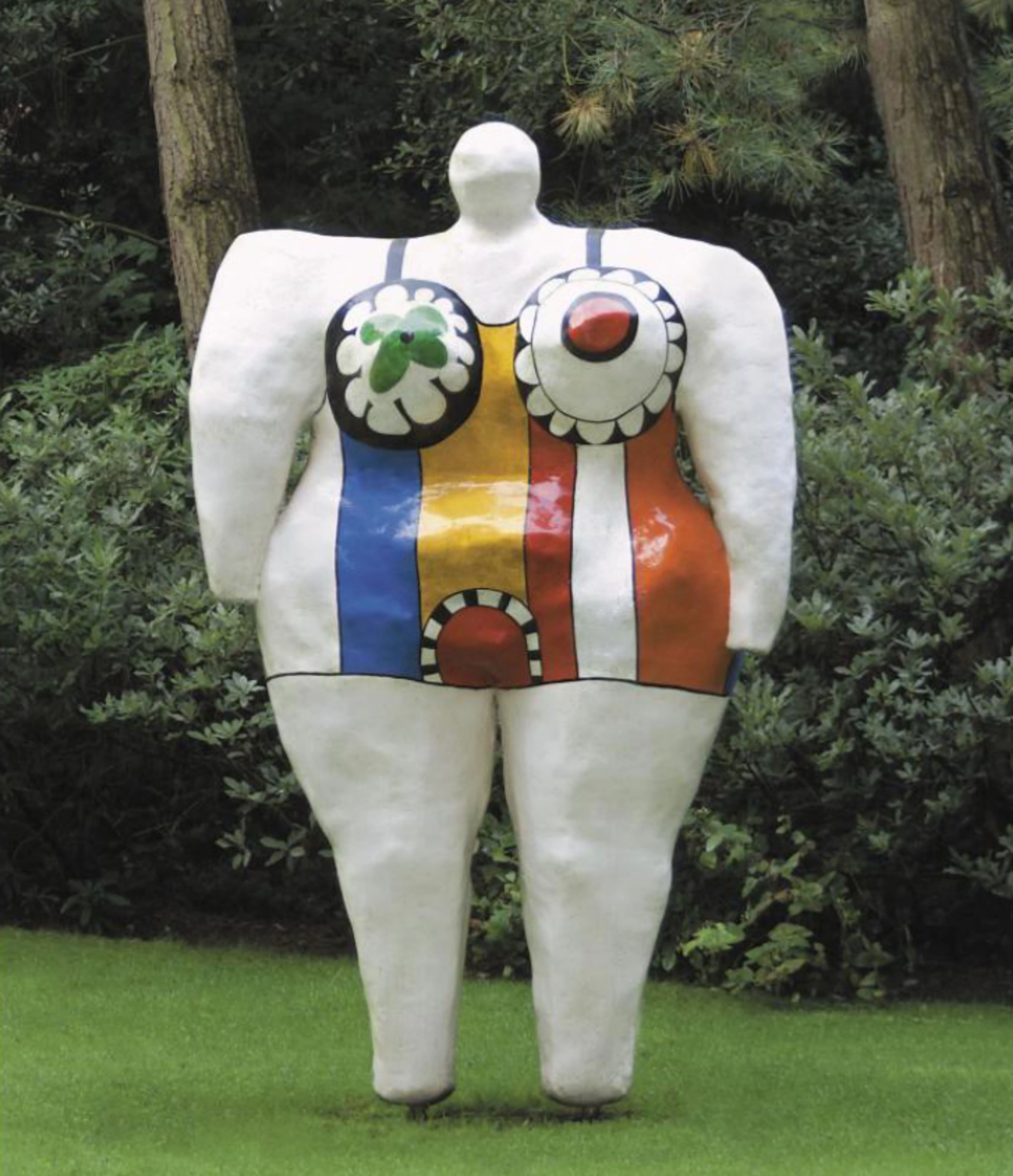 A monumental white sculptural female figure wearing colourfully striped clothes with large circular decorative designs.