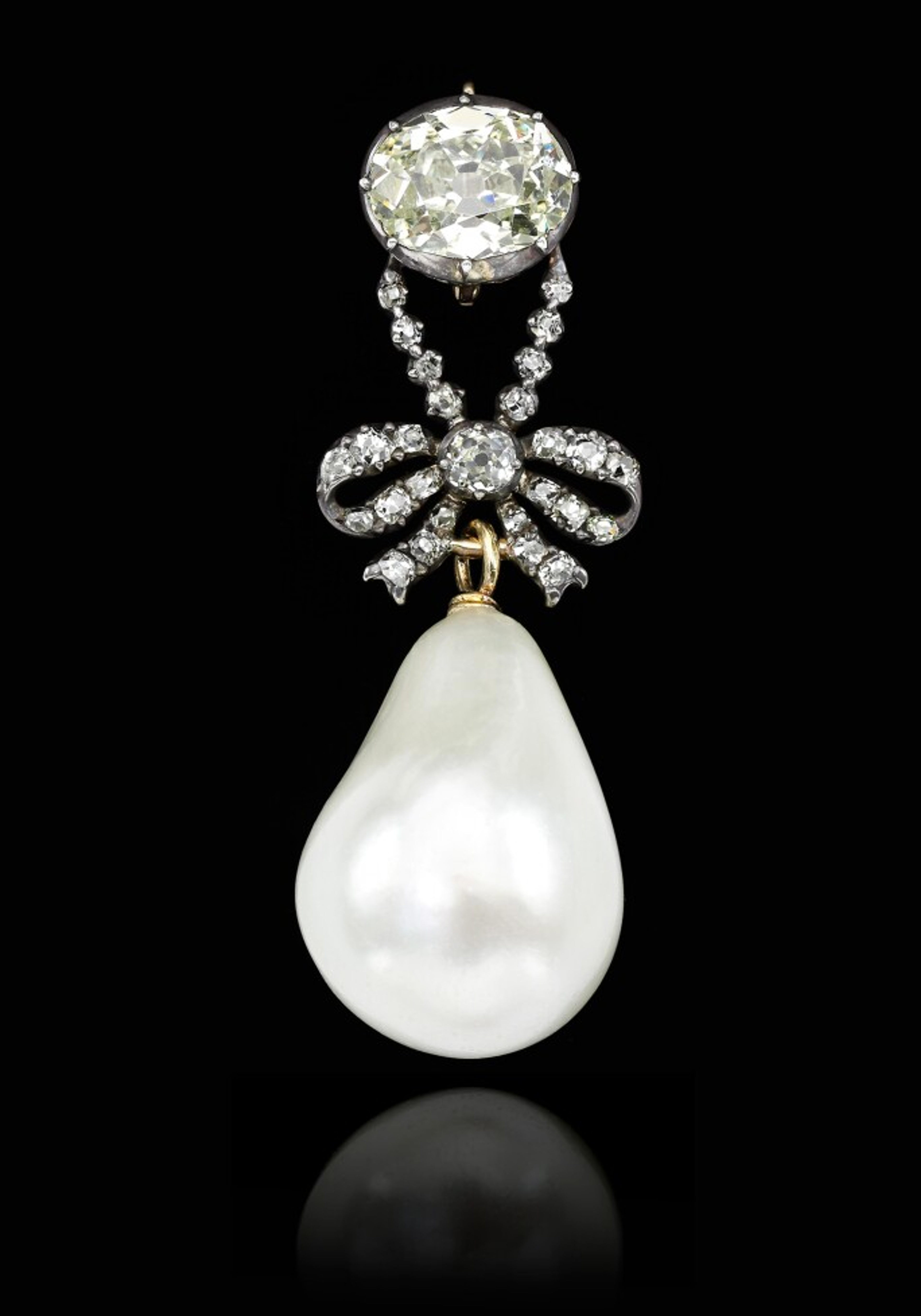 Une image d'un bijou porté par la reine Marie-Antoinette : un grand nœud en diamant suspendu à un solitaire en diamant de grande taille. Une grosse perle pâle pend sous le nœud.