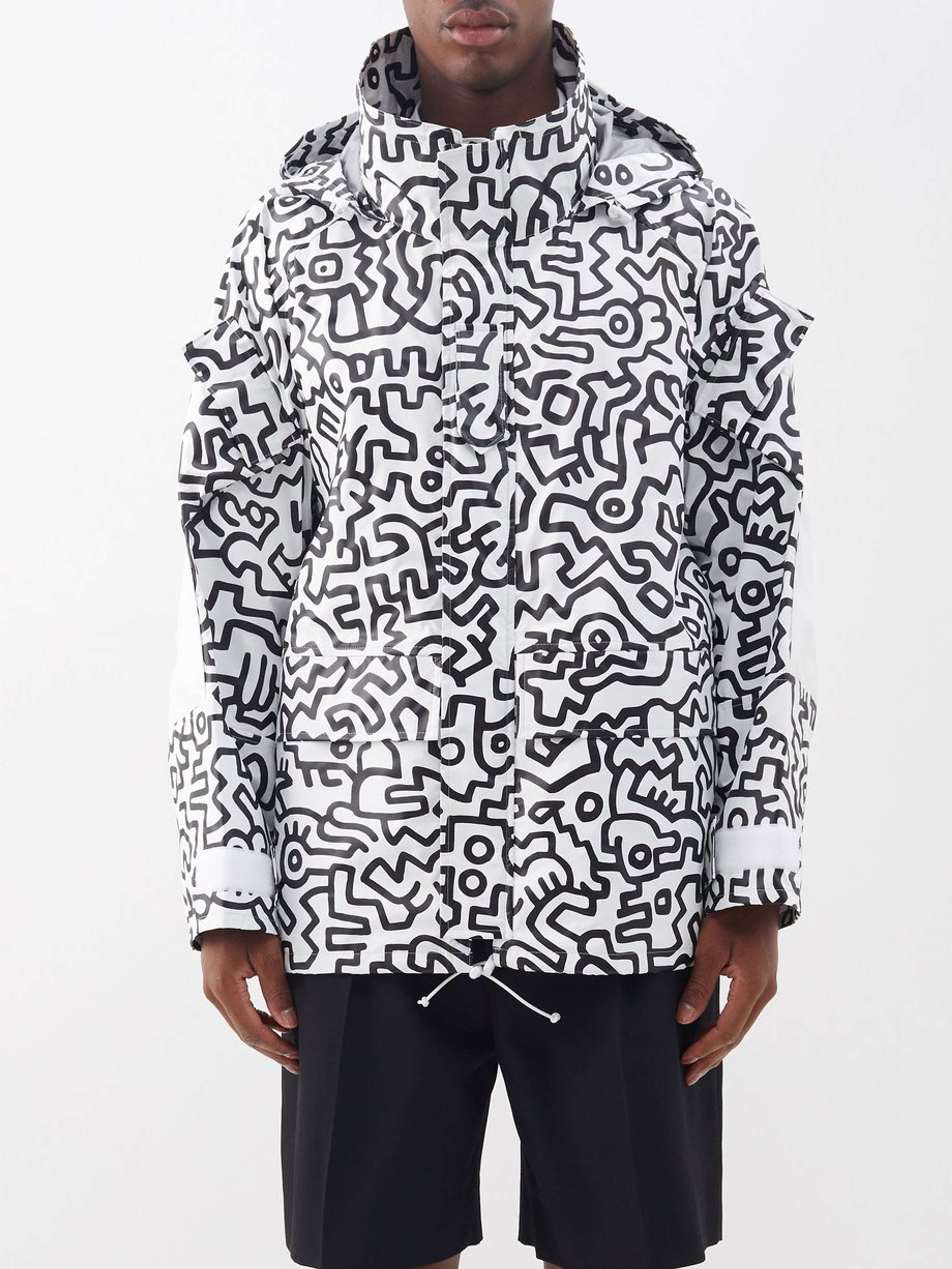 Une image d'un mannequin portant une veste Junya Watanabe blanche, entièrement recouverte des gribouillis caractéristiques noirs de Keith Haring.