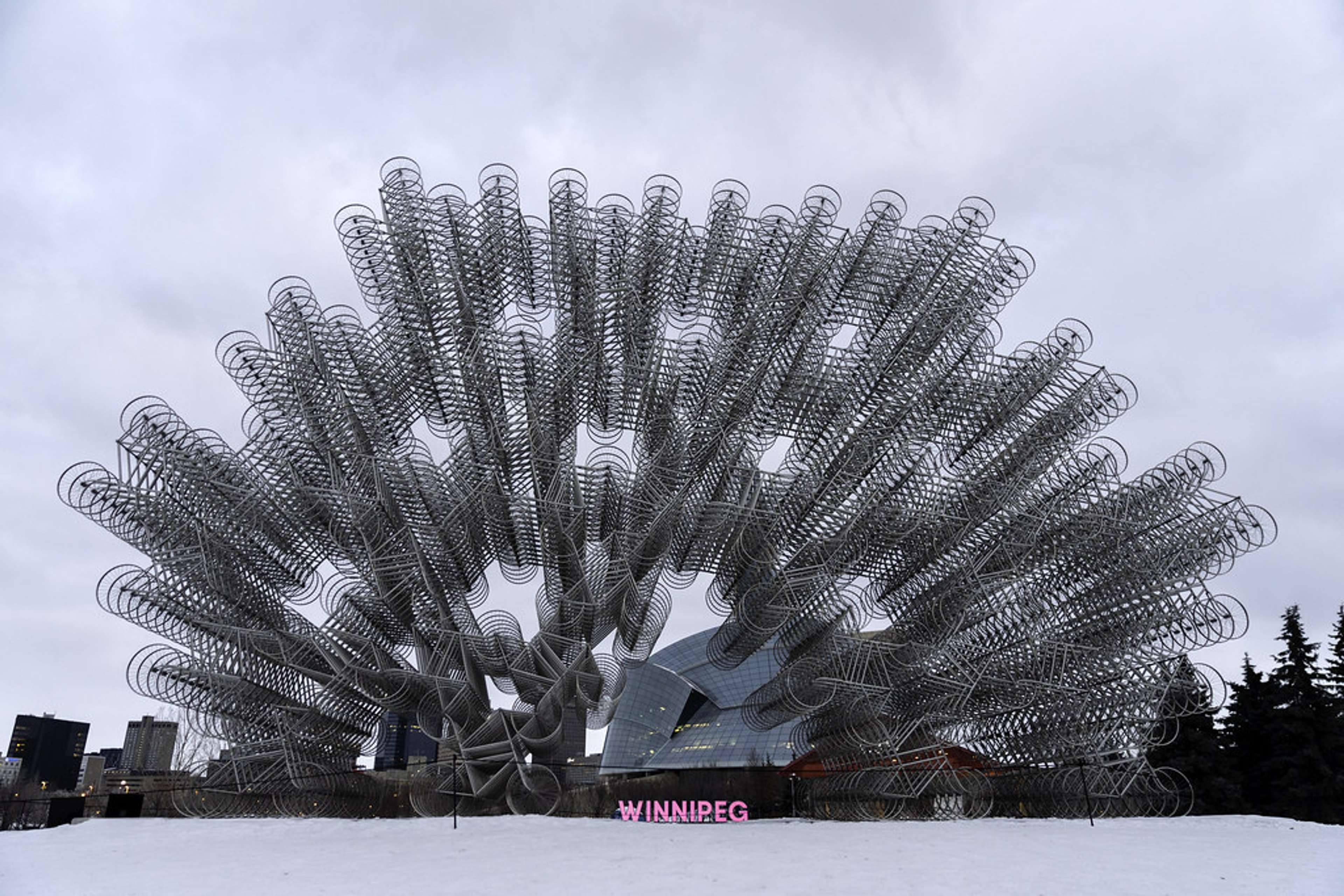 Forever Bicycles d'Ai Weiwei (2011). Des roues de vélo disposées en motif kaléidoscopique devant un bâtiment.