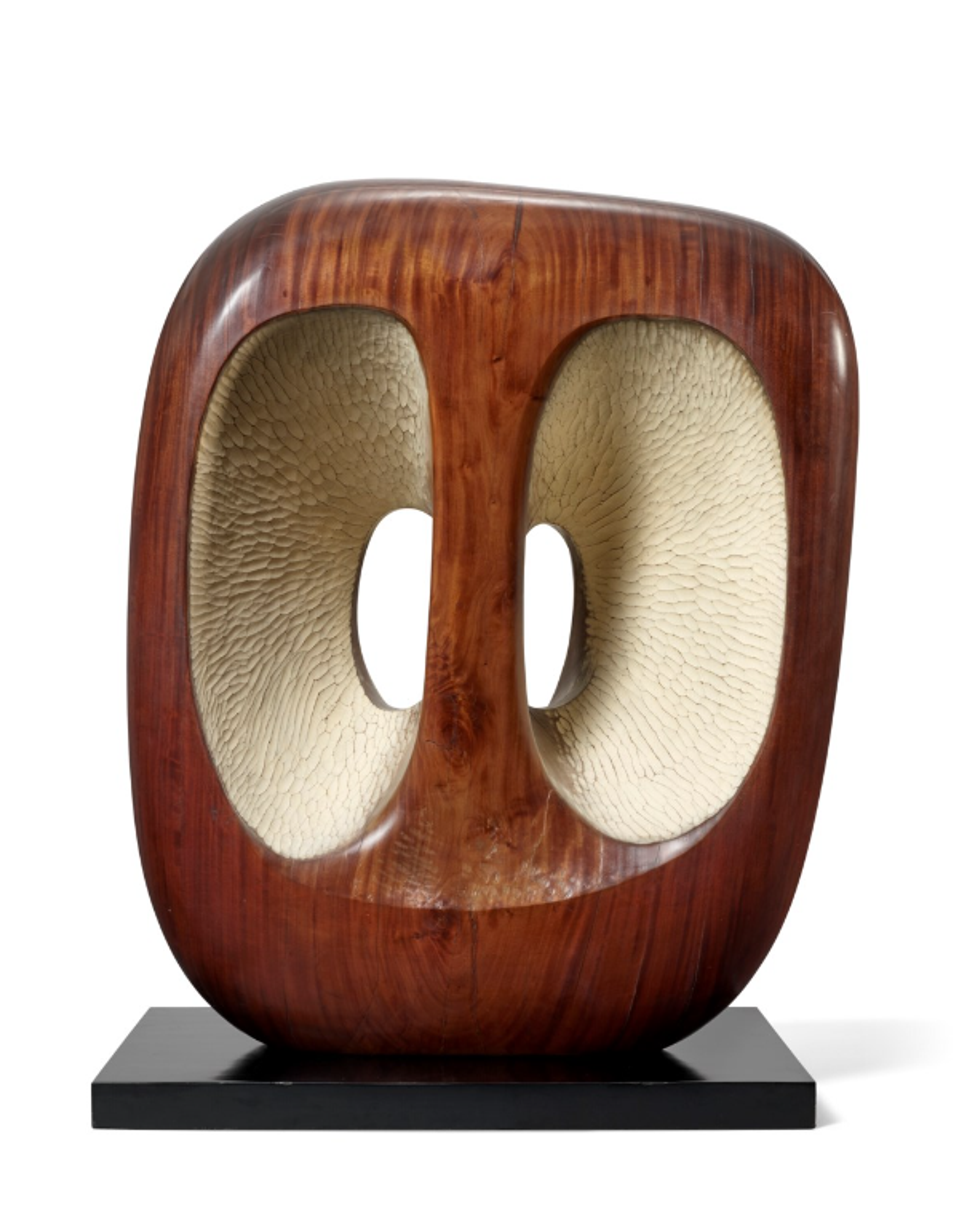 A wooden sculpture with a rounded rectangular form and hollow oval cavities on each side that connect in the centre. The exterior has a rich, reddish-brown wood finish with visible grain patterns, while the interior spaces are finished in a contrasting creamy white colour. 
