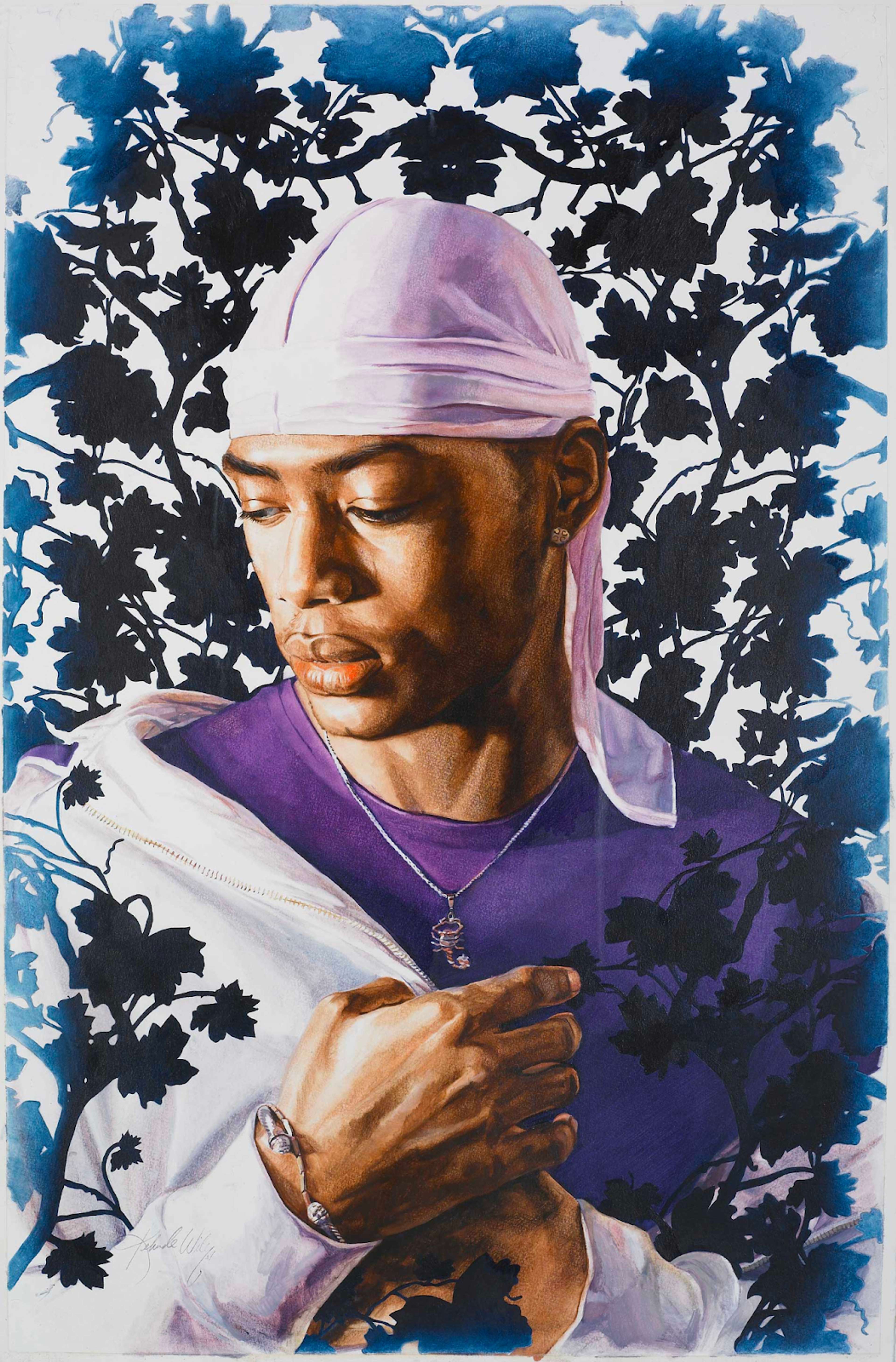 Un jeune homme pose portant un durag rose pâle, une chemise violet foncé et un sweat à capuche rose. Ses bijoux se composent d'une chaîne en argent avec un pendentif scorpion et d'un simple jonc d'argent, ainsi que de clous d'oreilles.