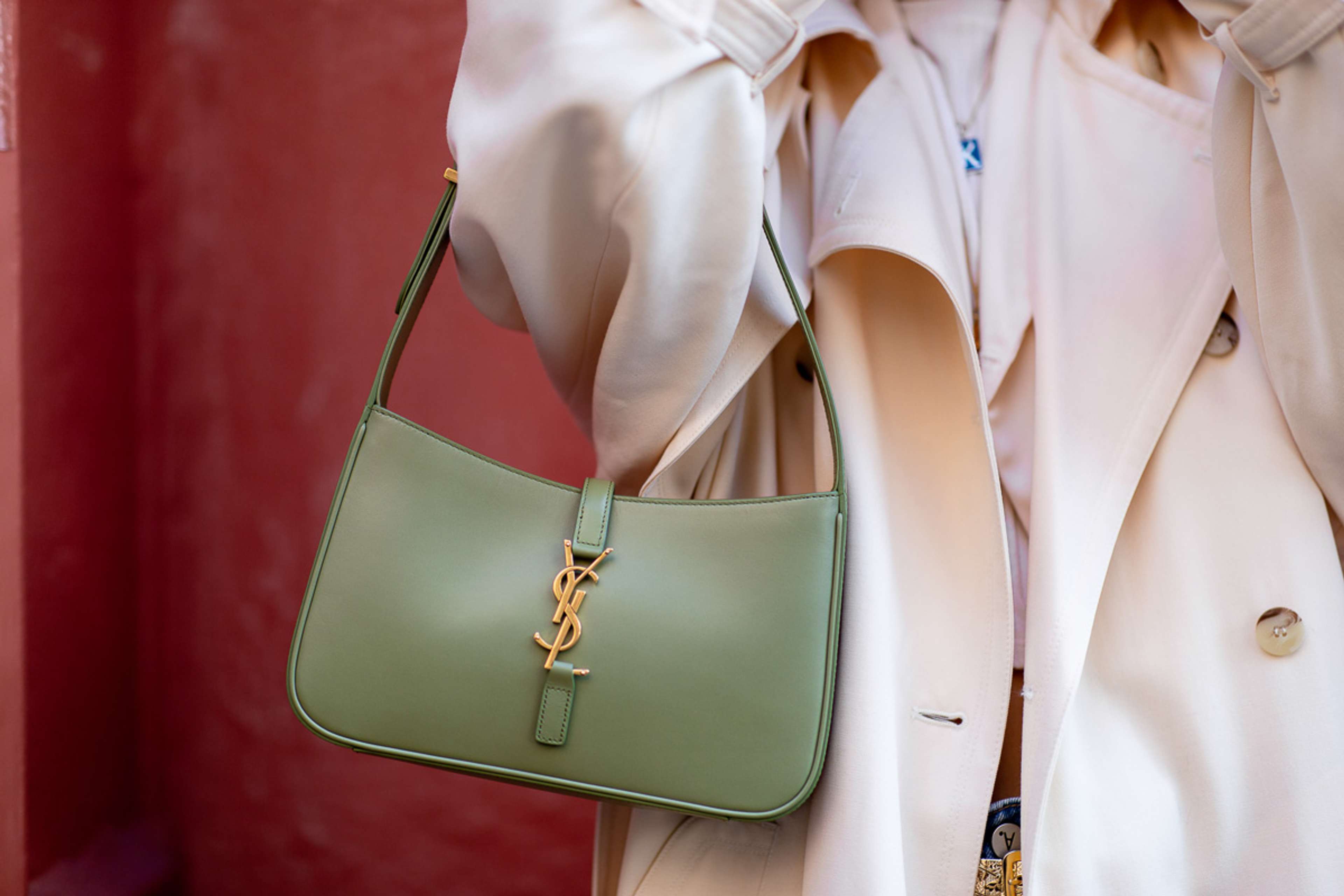 Une image d'un mannequin tenant un sac Le 5 à 7 vert d'Yves Saint Laurent.