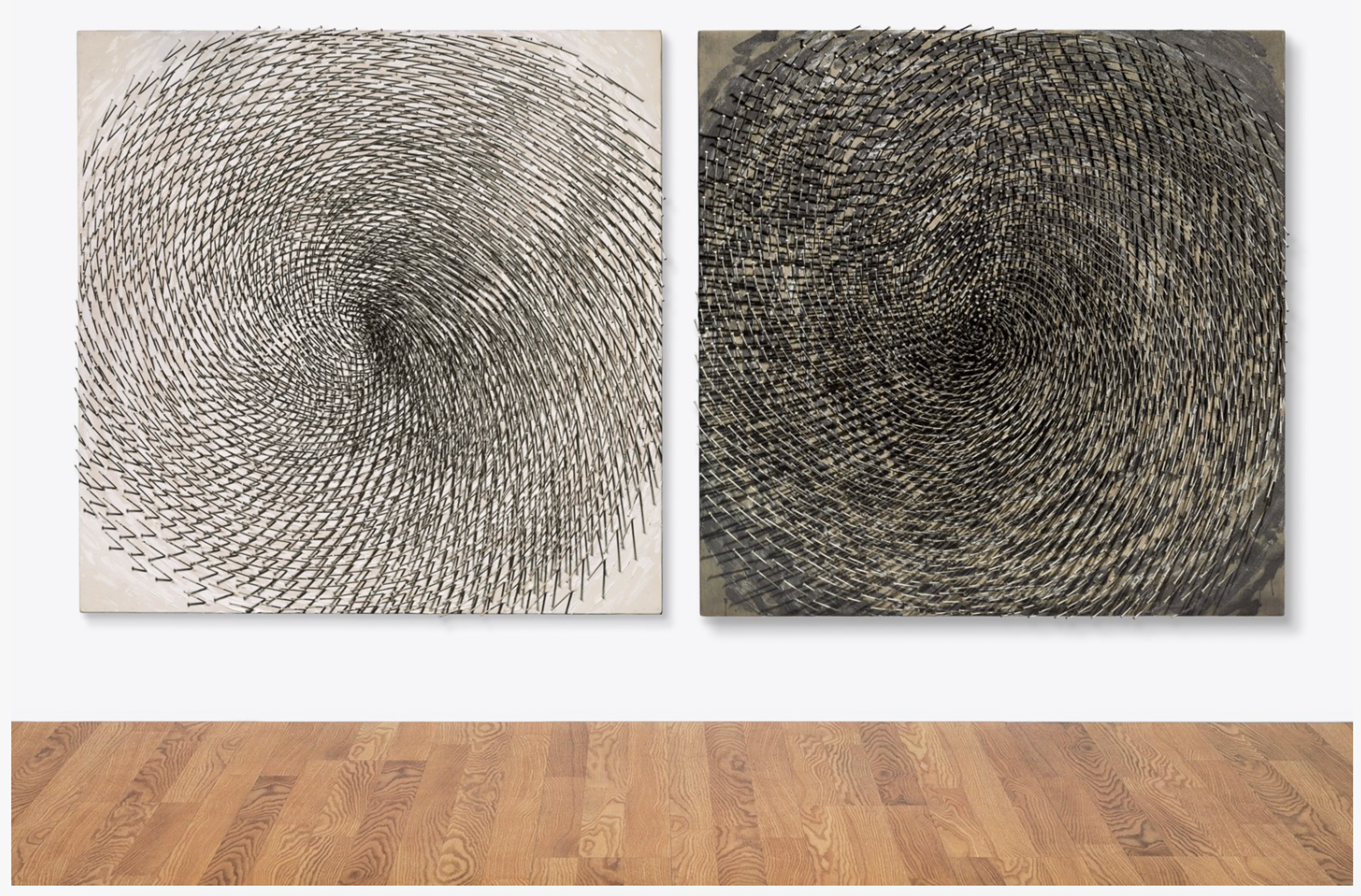 Two square canvases, one white and one deep grey. Both feature a single large spiral pattern formed by thousands of nails hammered into white surfaces. The centrifugal arrangements create whirlpools of light and shadow that appear to rotate as viewing angles change. Metallic nail heads reflect light against the background.