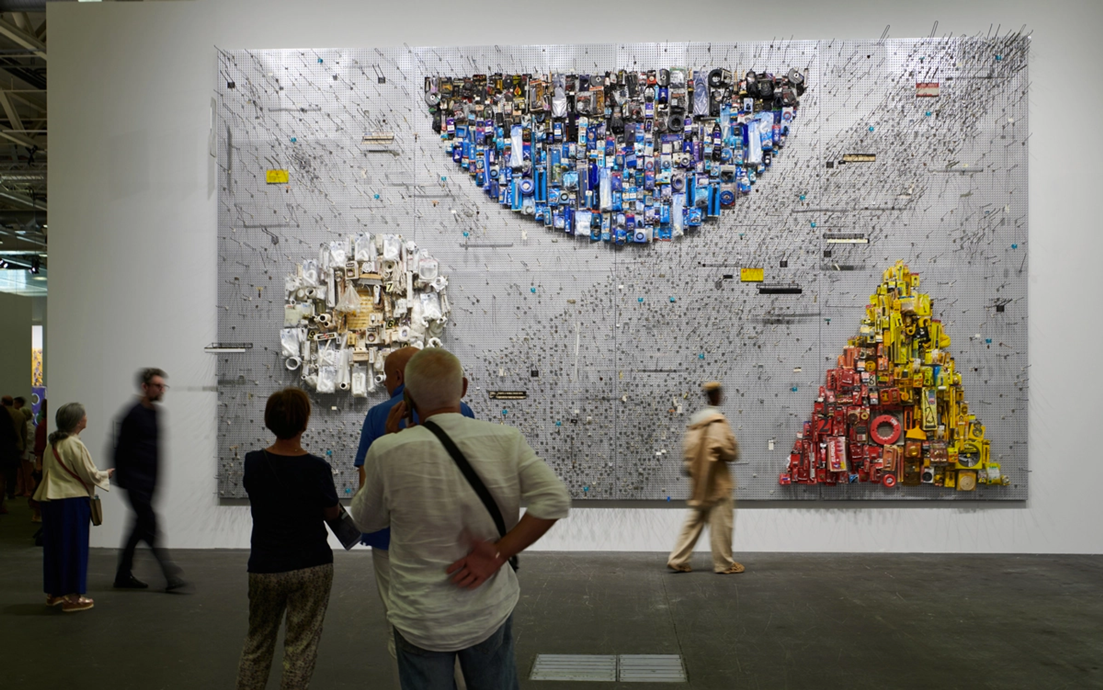 Vue de l'installation de Theaster Gates Hardware Store Painting, présentant un triangle en dégradé rouge et jaune, un cercle blanc et un demi-cercle bleu.