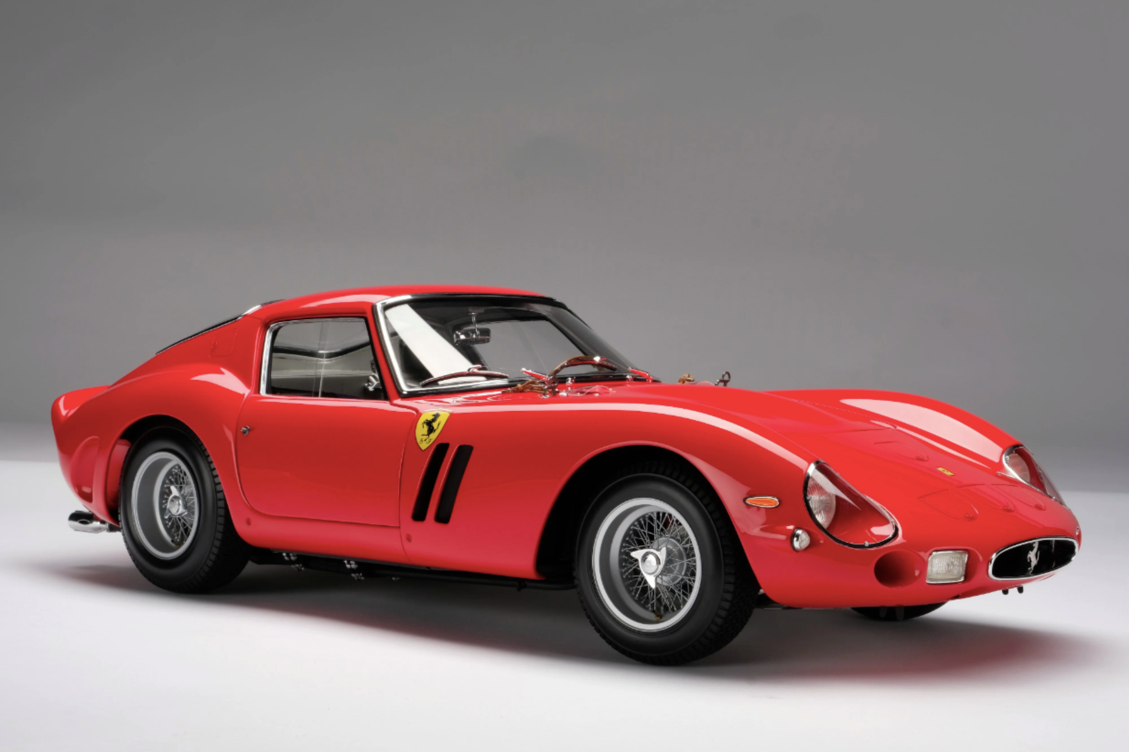 Une Ferrari 250 GT écarlate sur fond gris.