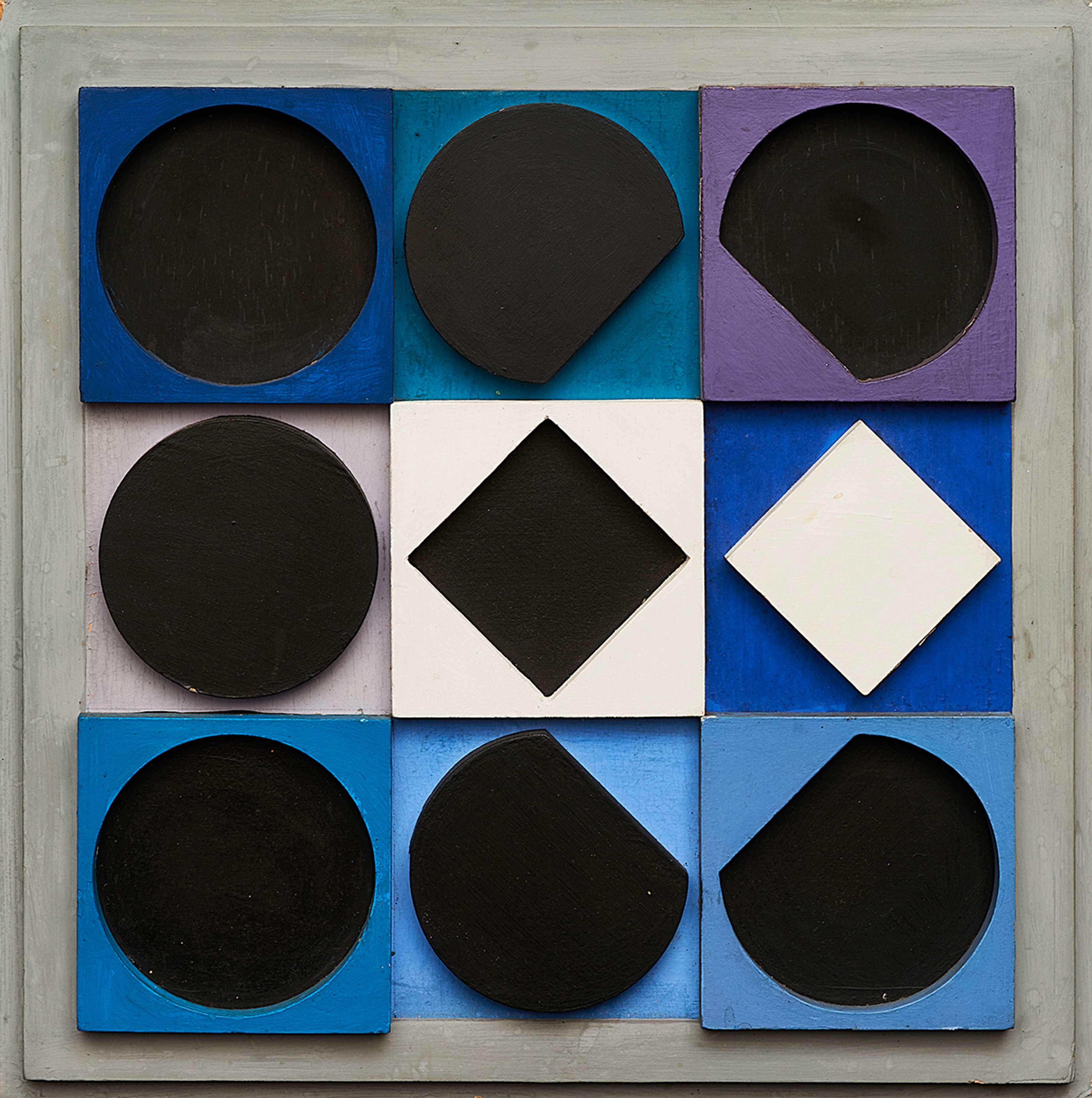 Topaze Noire Negatif de Victor Vasarely (1967). Une multiple en bois en relief, composée de formes circulaires et de carrés sur une grille, dans les tons de bleu, de nuances, de violet, de noir et de blanc.