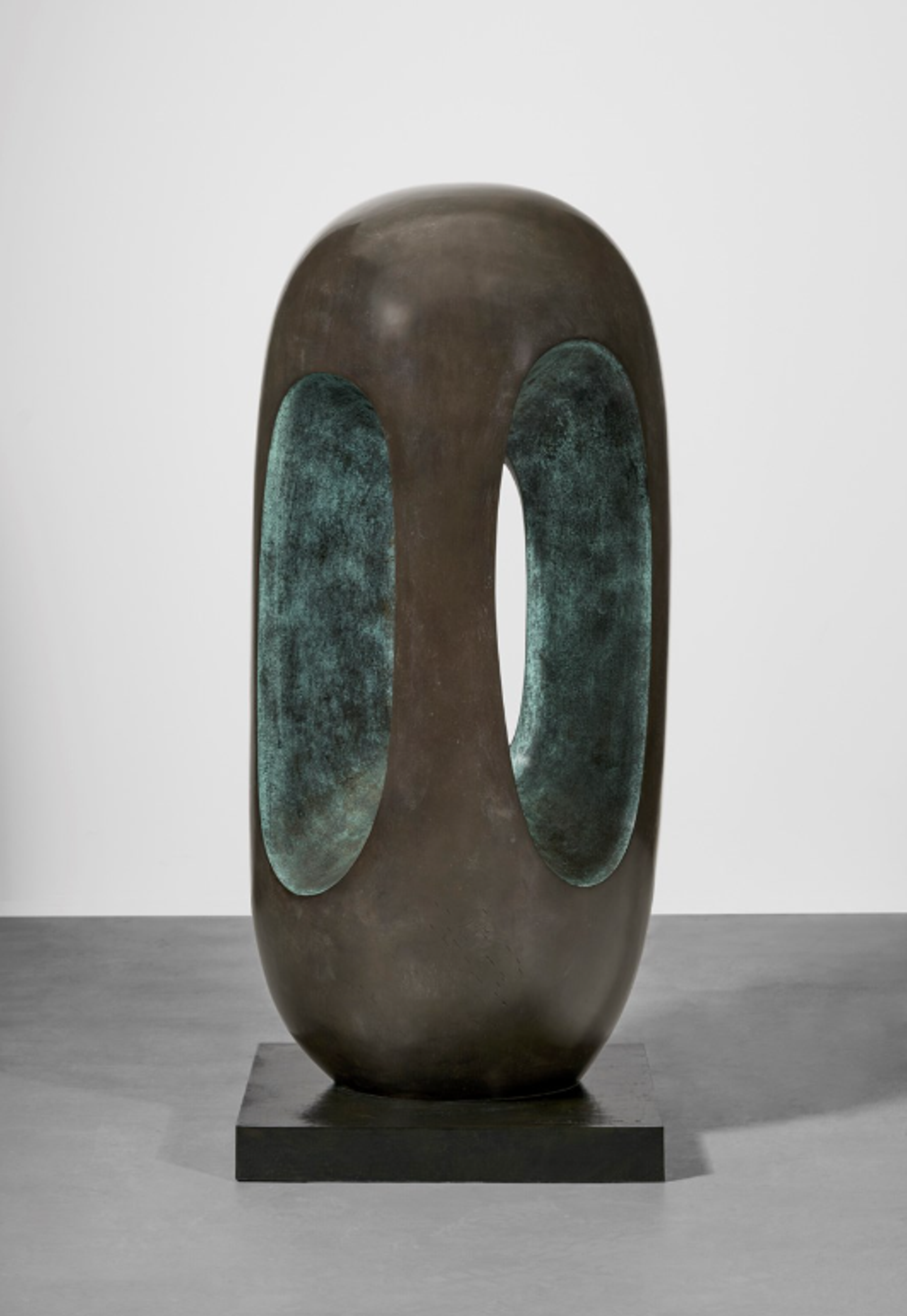 An oval-shaped bronze sculpture with smooth, rounded exterior surfaces and elongated vertical openings revealing an interior space. The form suggests an egg or seed shape with an organic, biomorphic quality. The bronze has a warm brown patina with subtle green tones visible in certain areas.