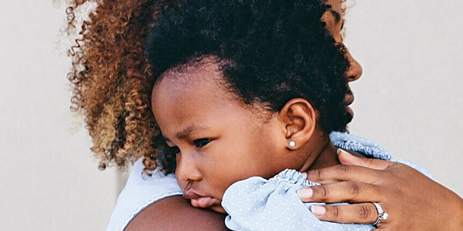 Parent comforting a child after a minor injury, representing gentle homeopathic first aid care.
