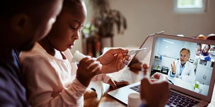 Parent and child attending an online homeopathy consultation with a certified homeopathic doctor via video call from home.