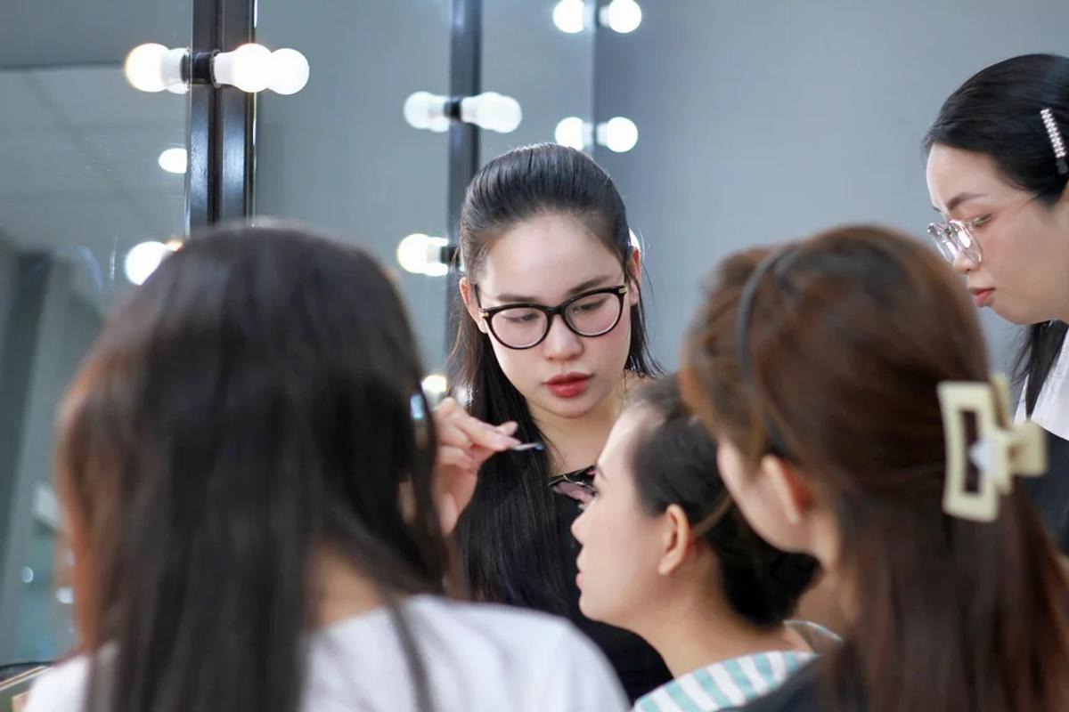 Không khí lớp thực hành: giảng viên quan sát và sửa từng thao tác trên gương mặt học viên.