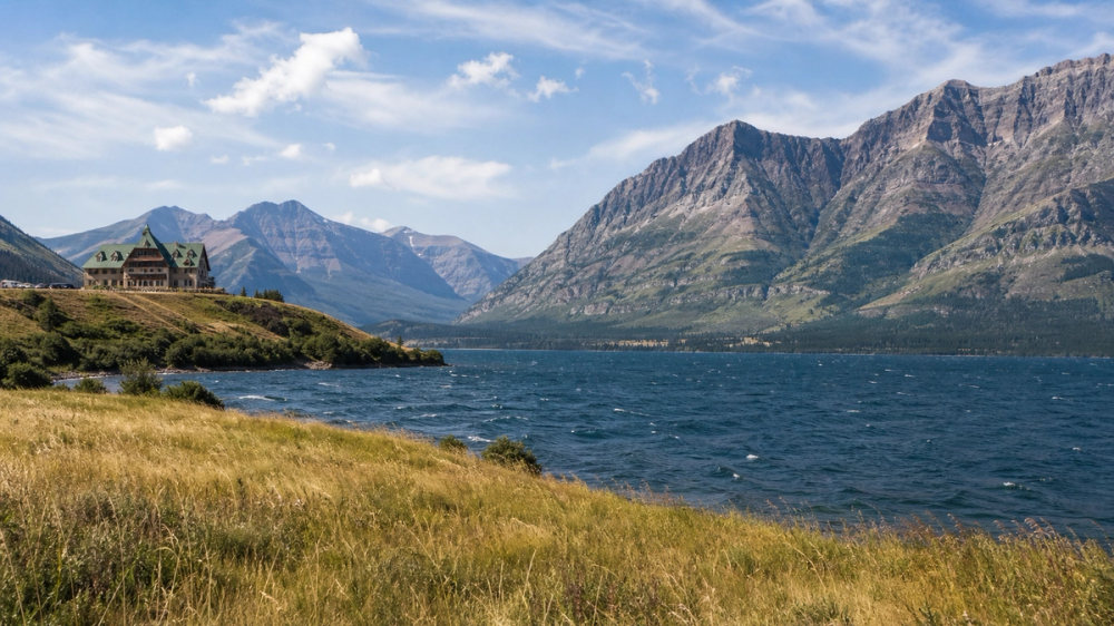 Waterton Lakes National Park with prairie grass, lake and mountain peaks