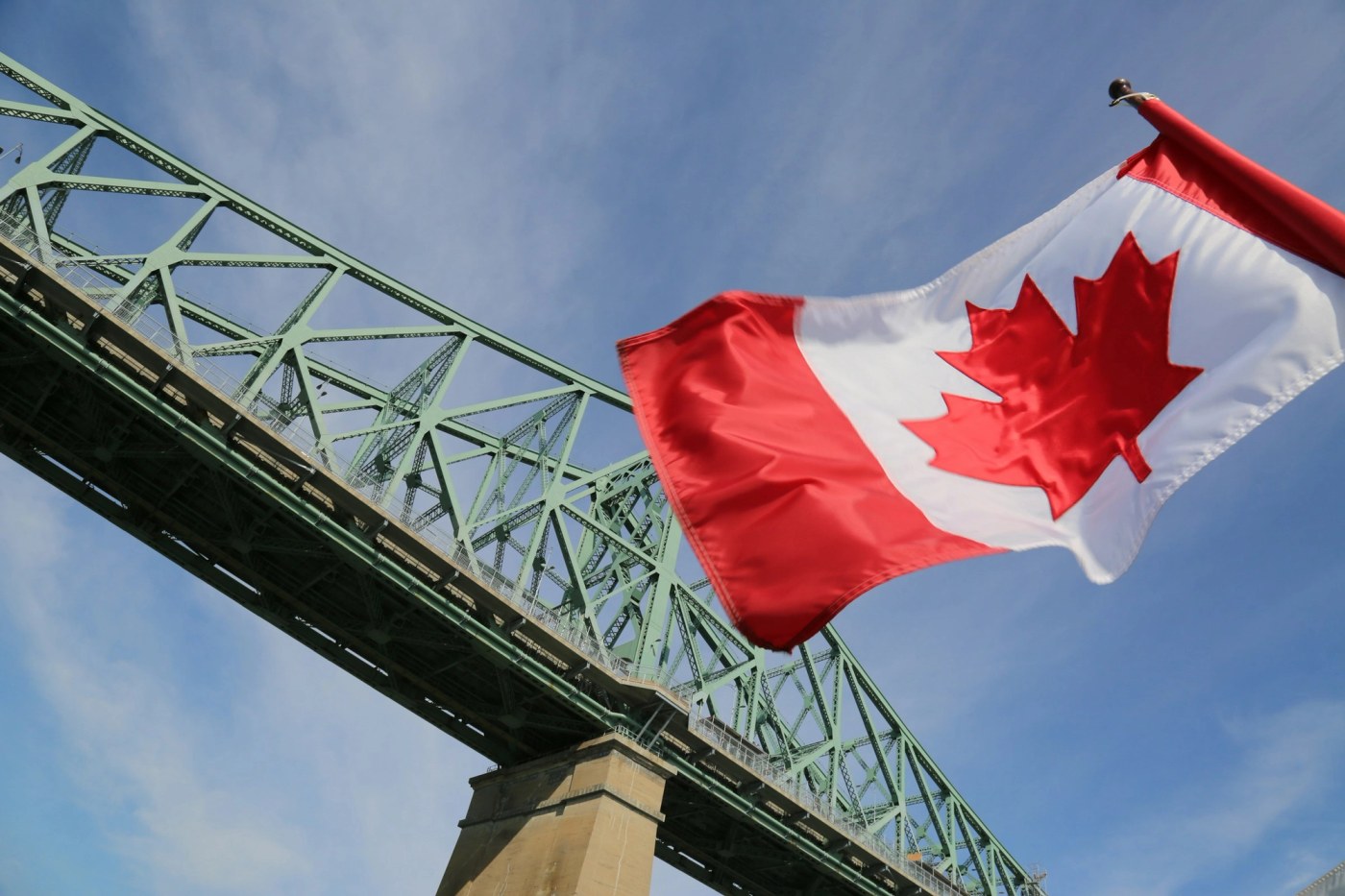 Canadian flag flying in front of a roller coaster in Montreal, Quebec