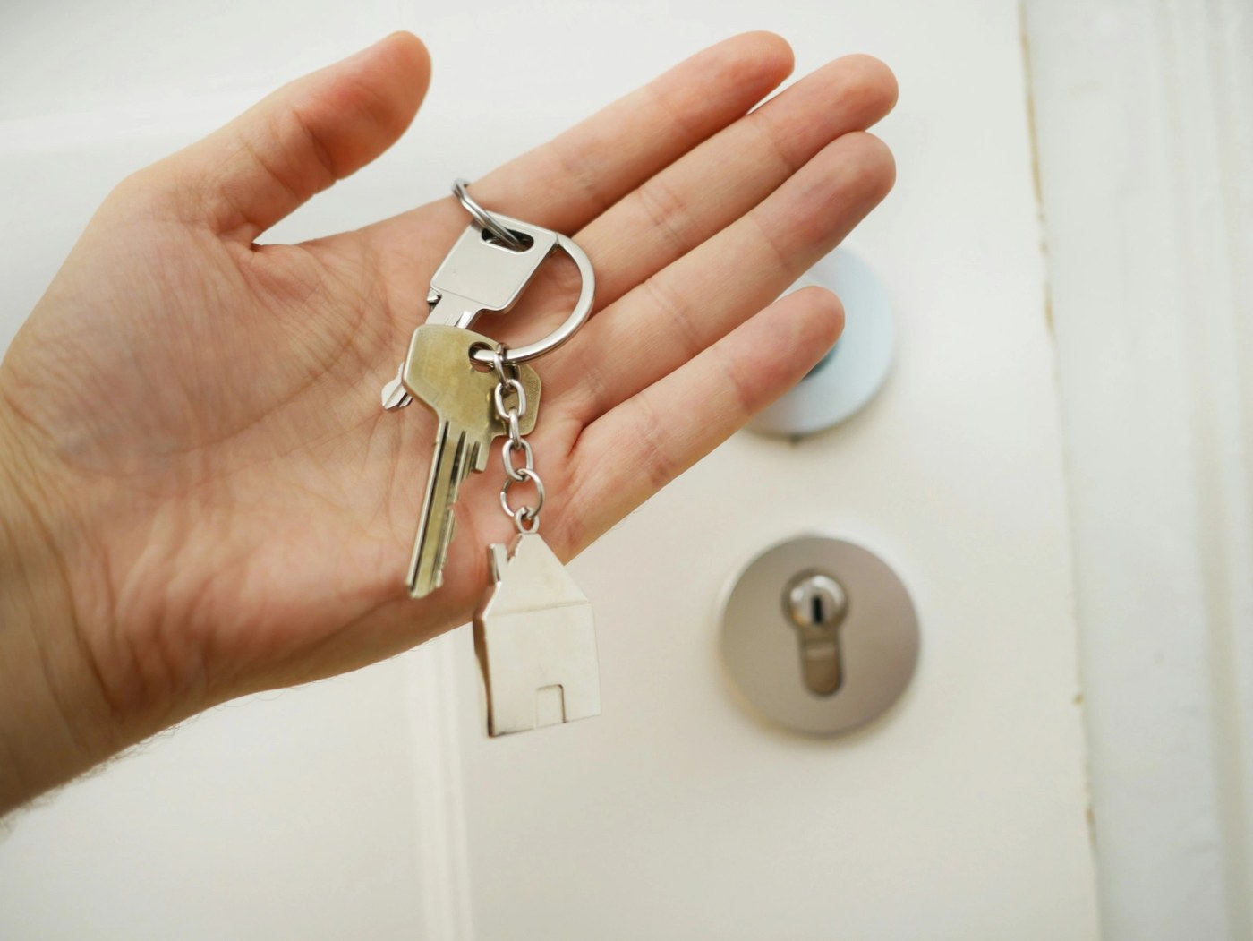 A set of house keys held in an open hand