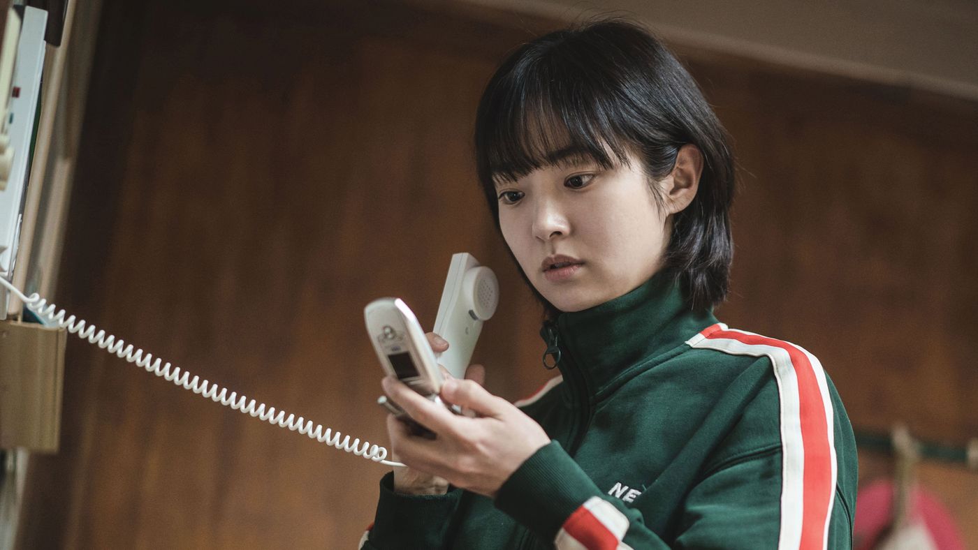 Jeong Ji-an memegang telepon rumah dengan ekspresi serius dalam A Shop for Killers