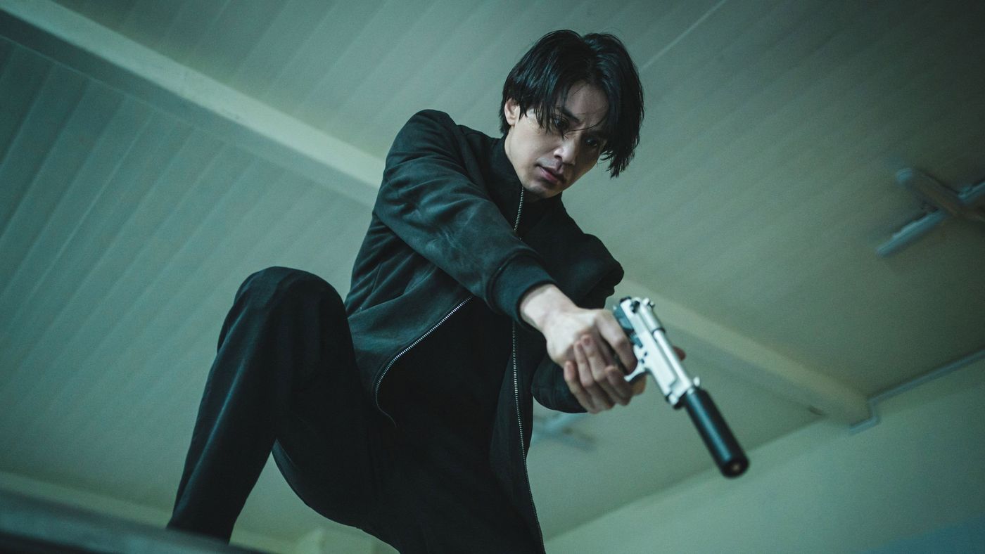 Jeong Jin-man membidik pistol dengan sudut pengambilan rendah dalam A Shop for Killers