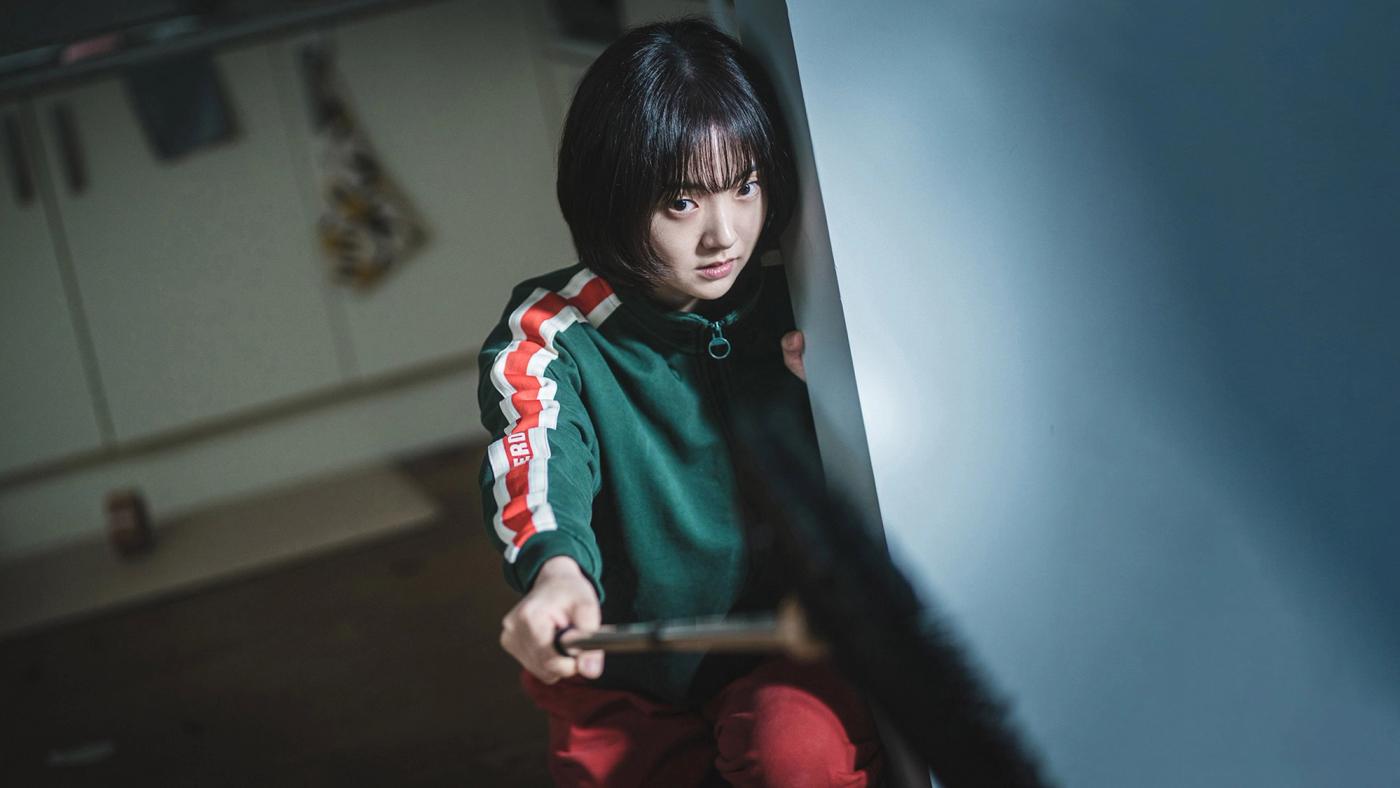 Jeong Ji-an bersembunyi sambil memegang alat panah dalam A Shop for Killers