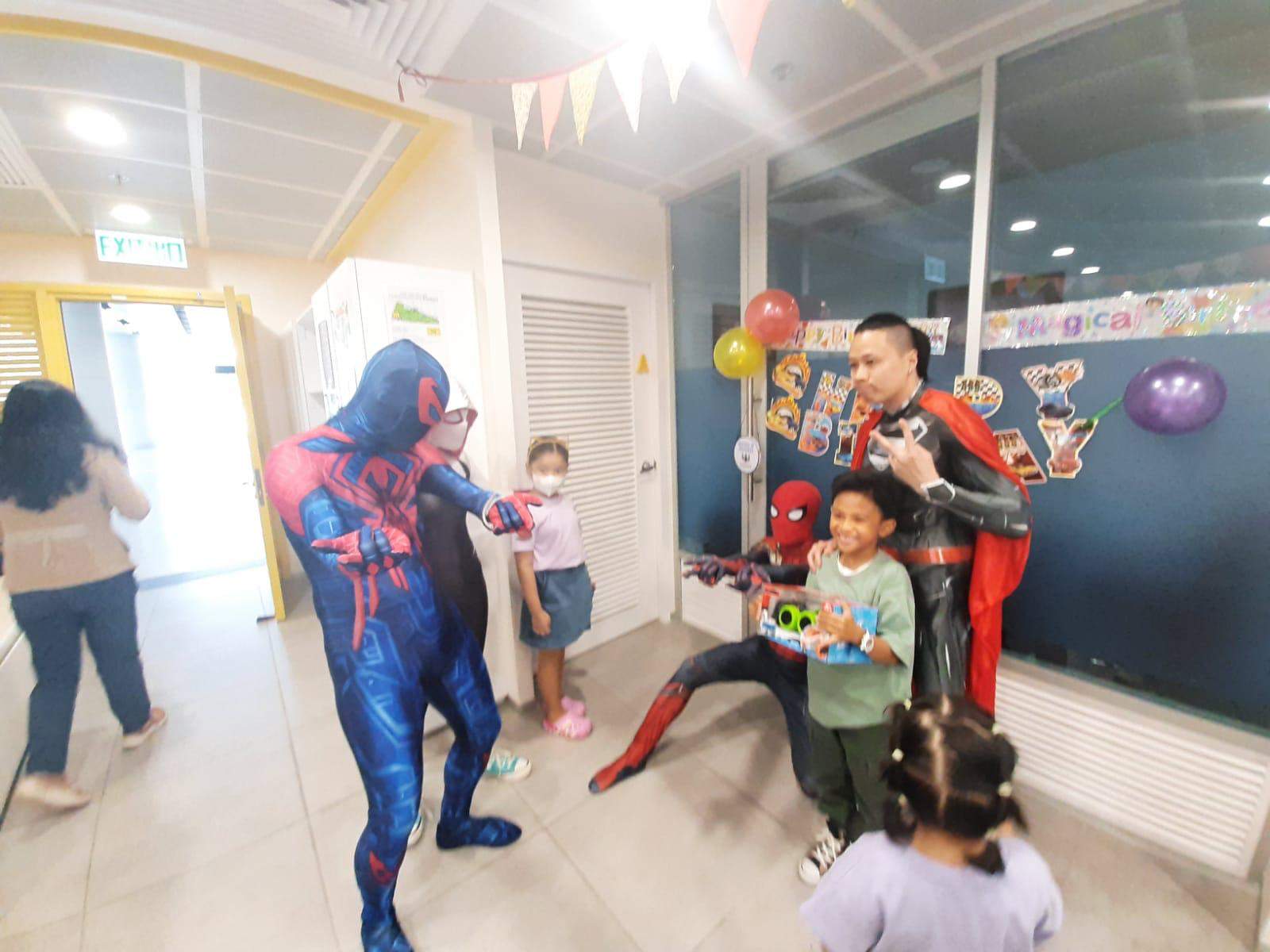 Costumed performers lead an activity while children gather nearby.