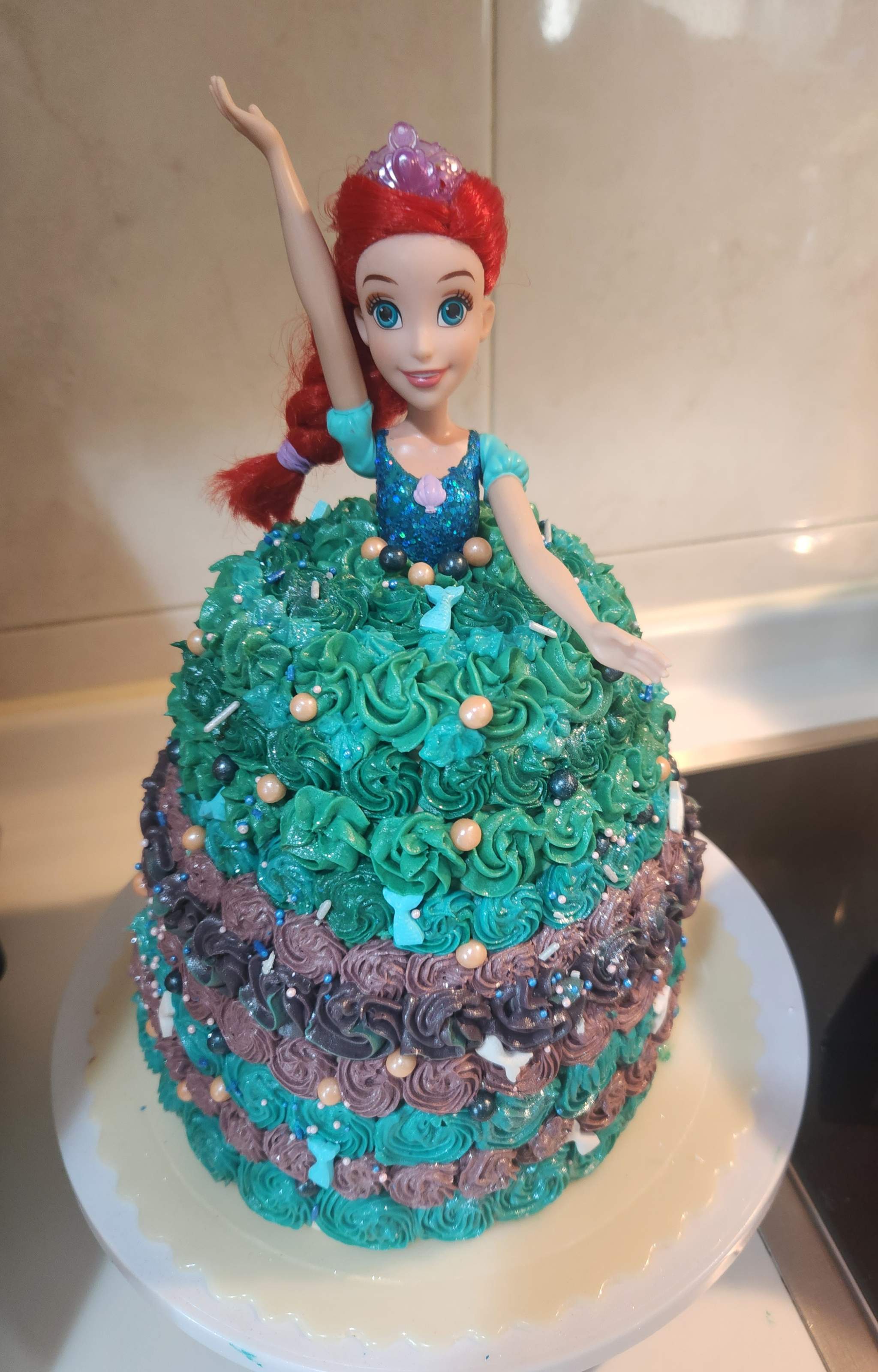 A Little Mermaid doll cake with teal rosette frosting, by Mabel Chan.