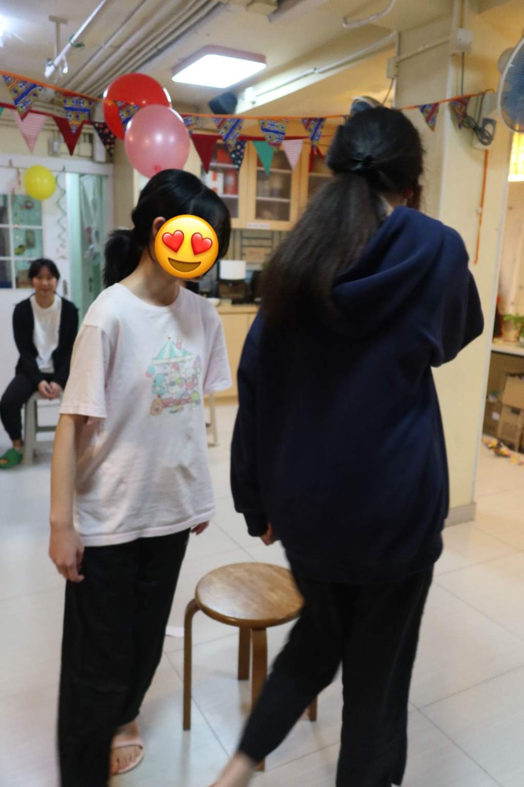 Two people face each other near a decorated party table.