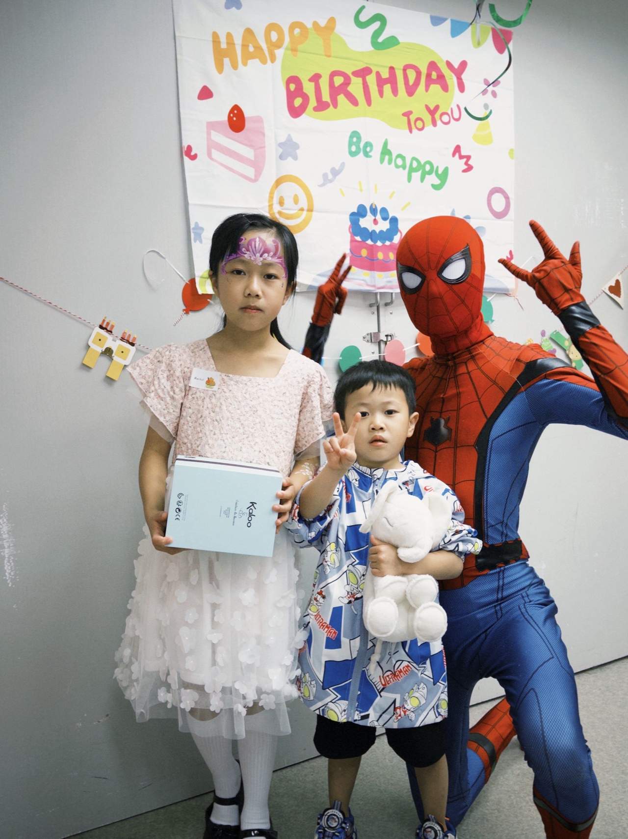 An adult, two children, and a costumed performer pose together.