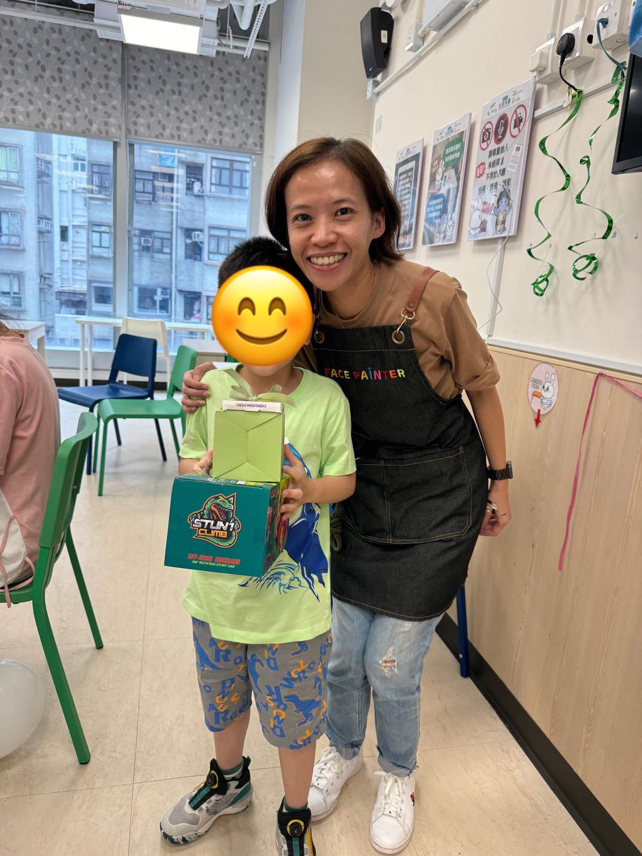 An adult poses with a child holding two gift bags.