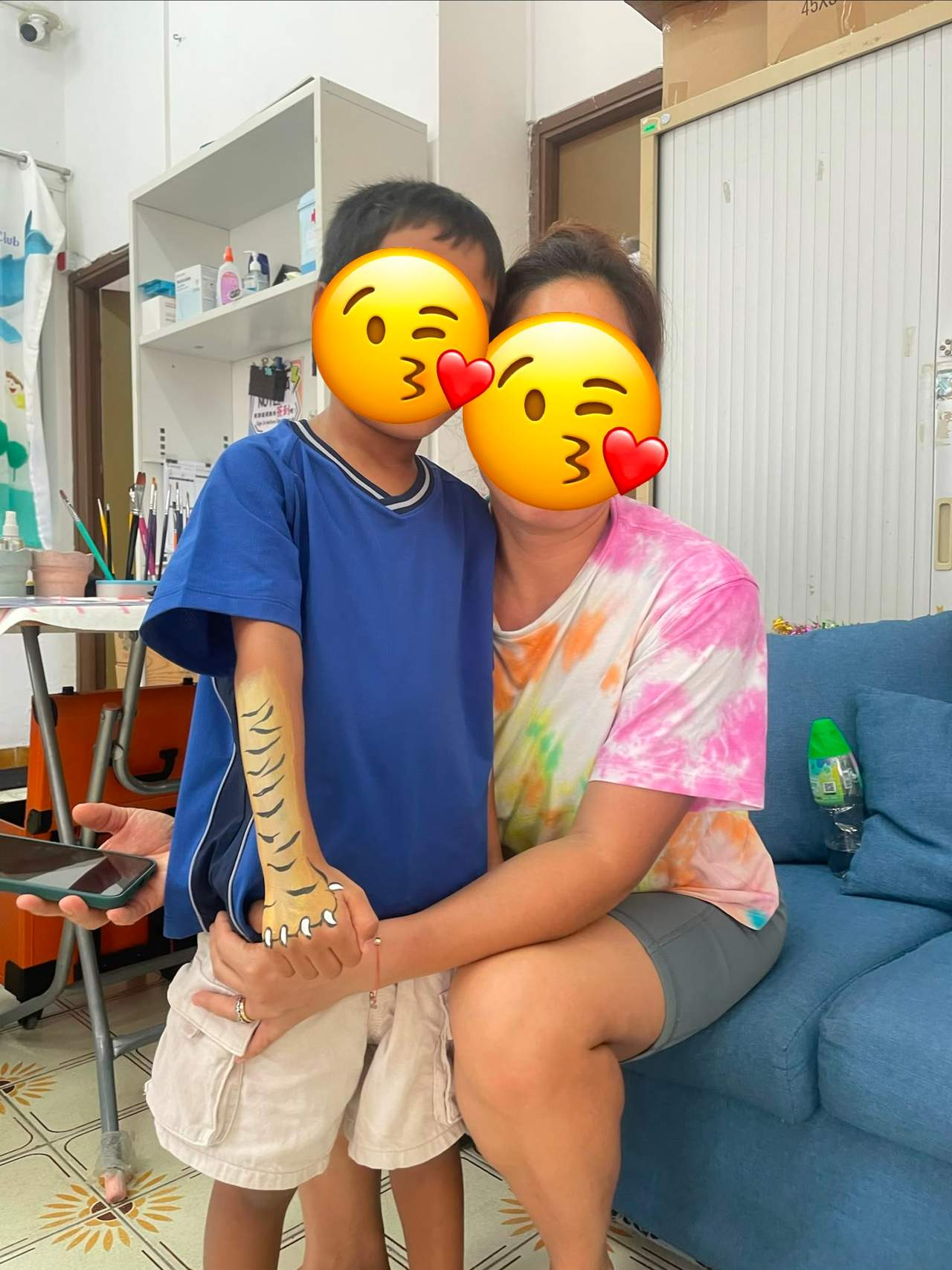 An adult and child sit together on a sofa.