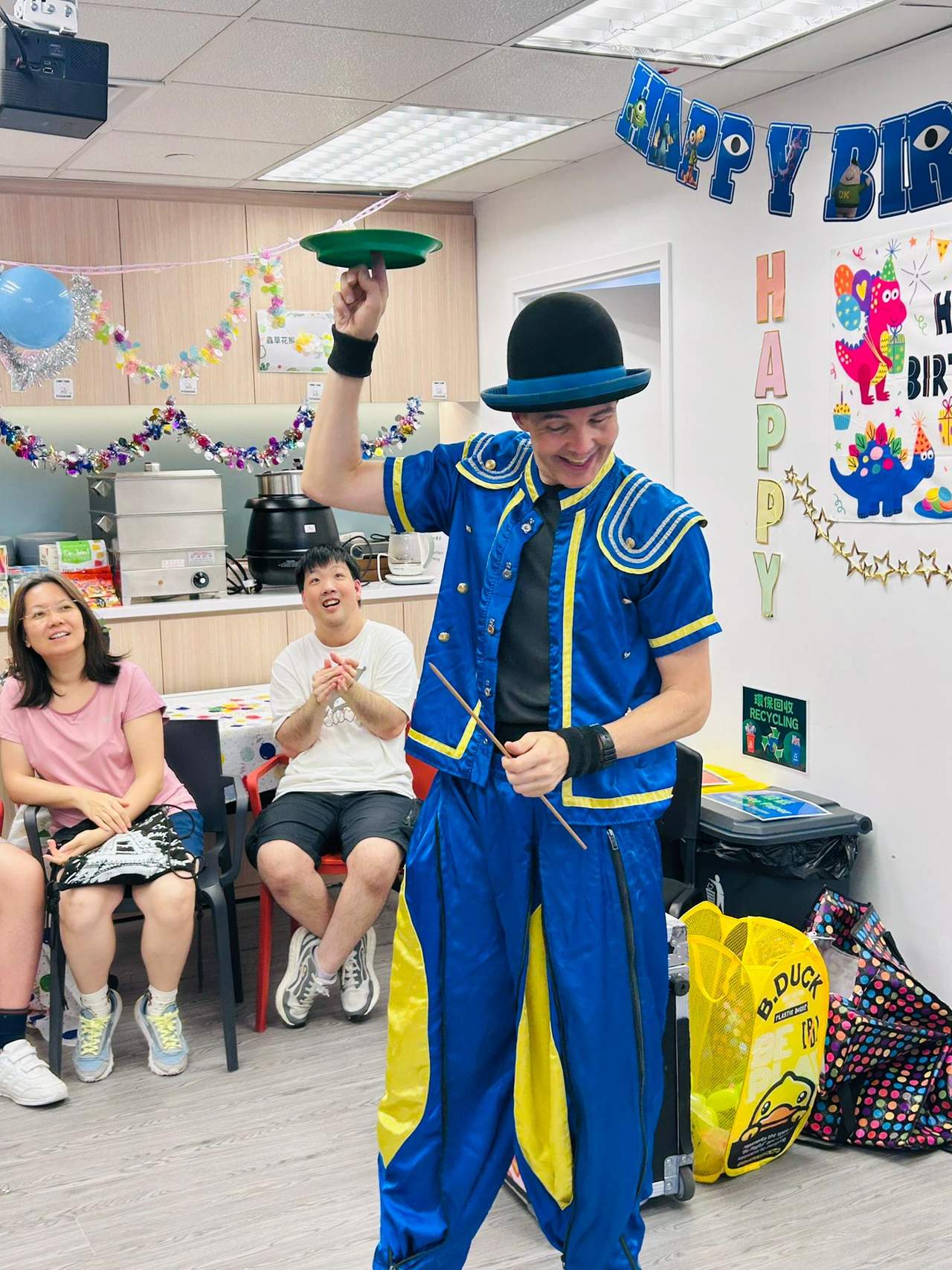 A performer spins a plate while seated people watch.