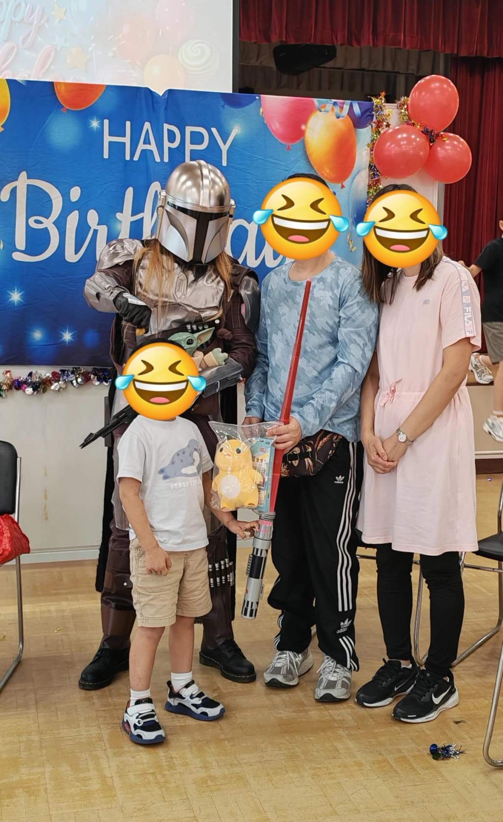 A child and adults pose with a gift and armored character.