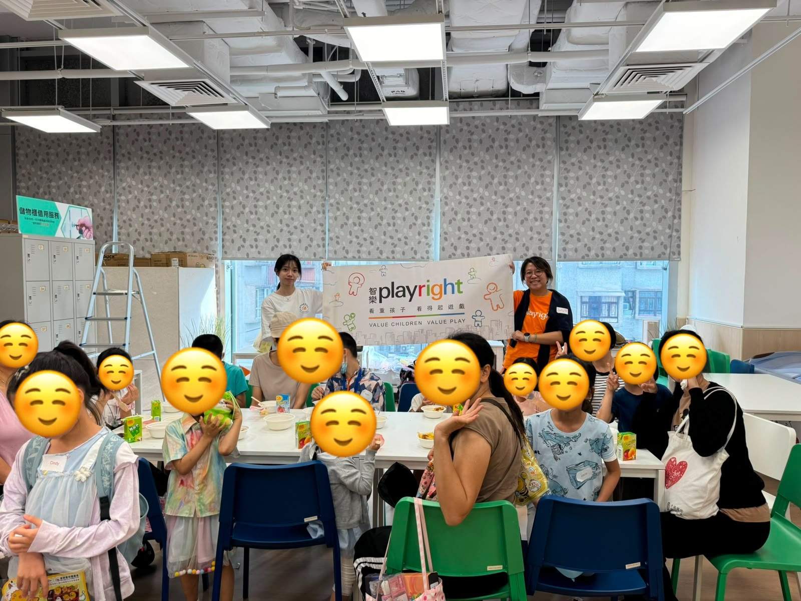 Participants gather at tables beneath a volunteer banner.