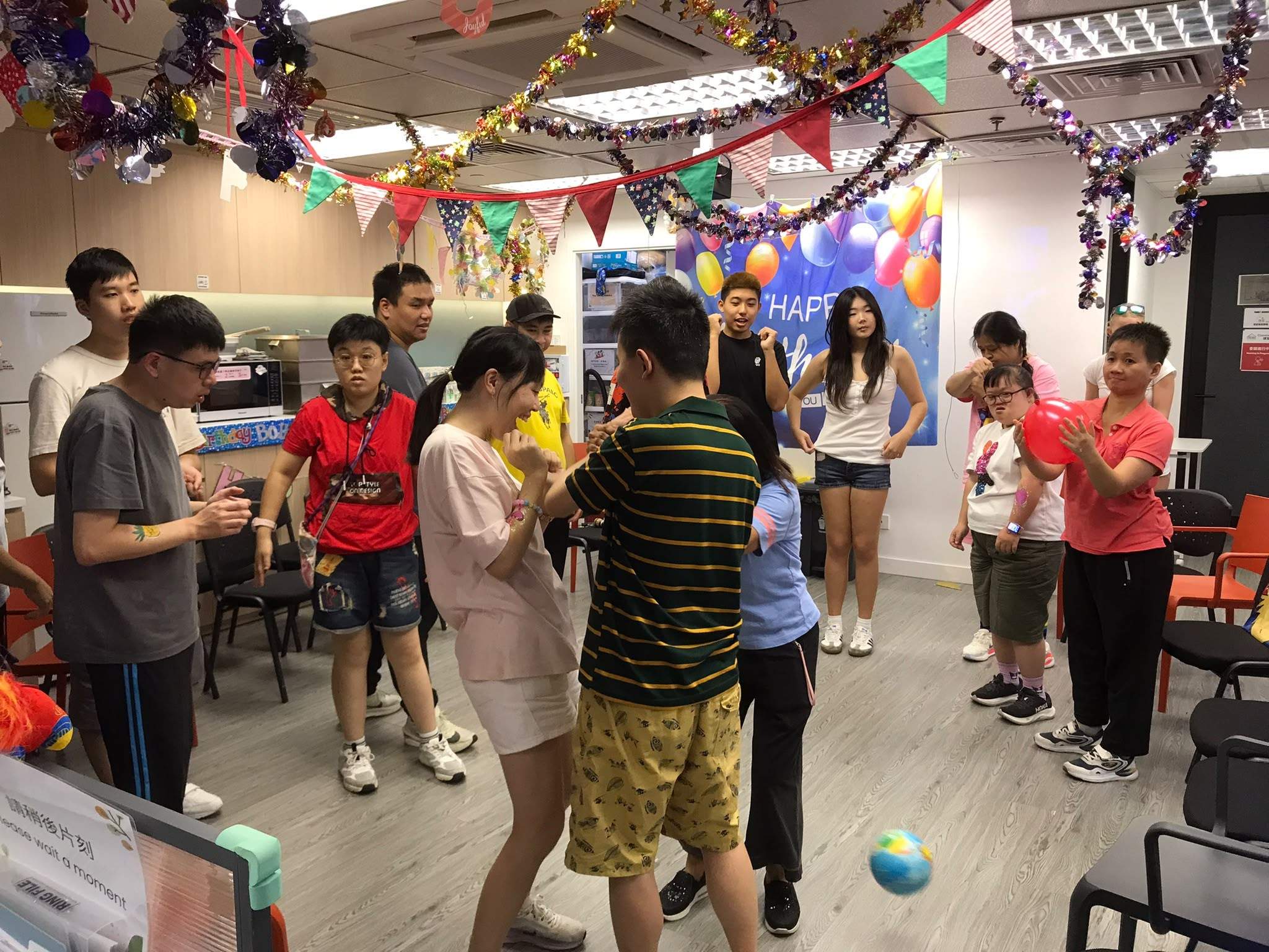 Participants gather closely during a lively indoor ball game.
