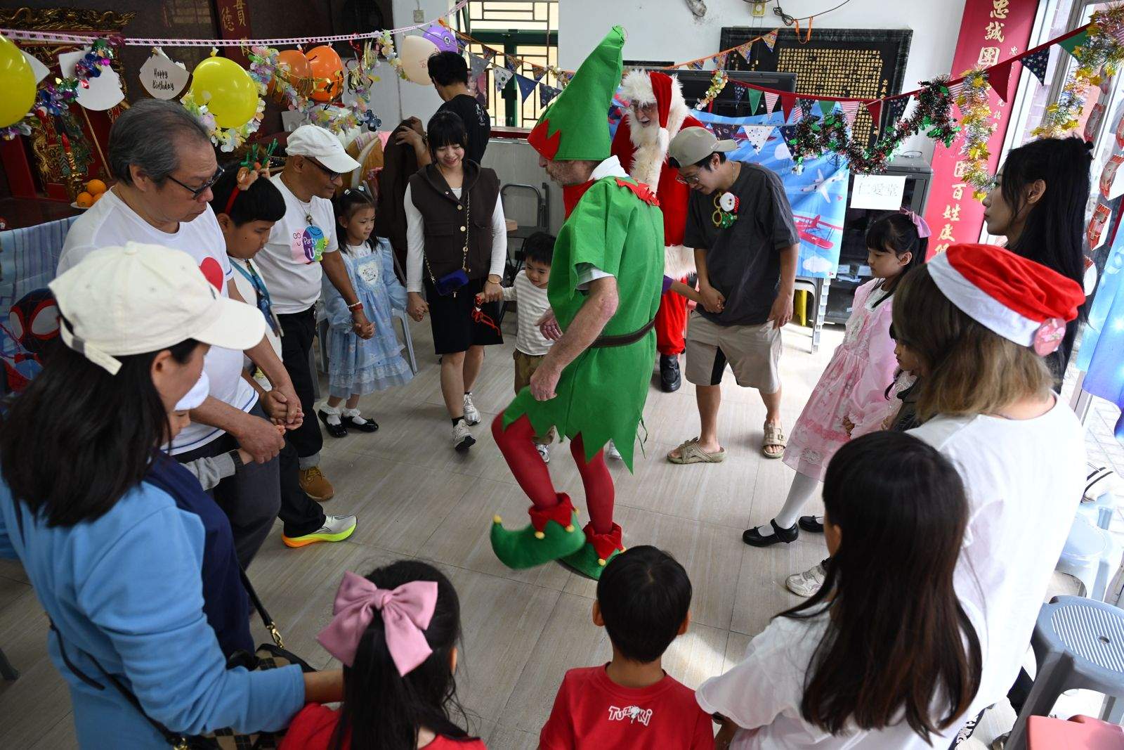 Children watch a costumed performer during a group activity.