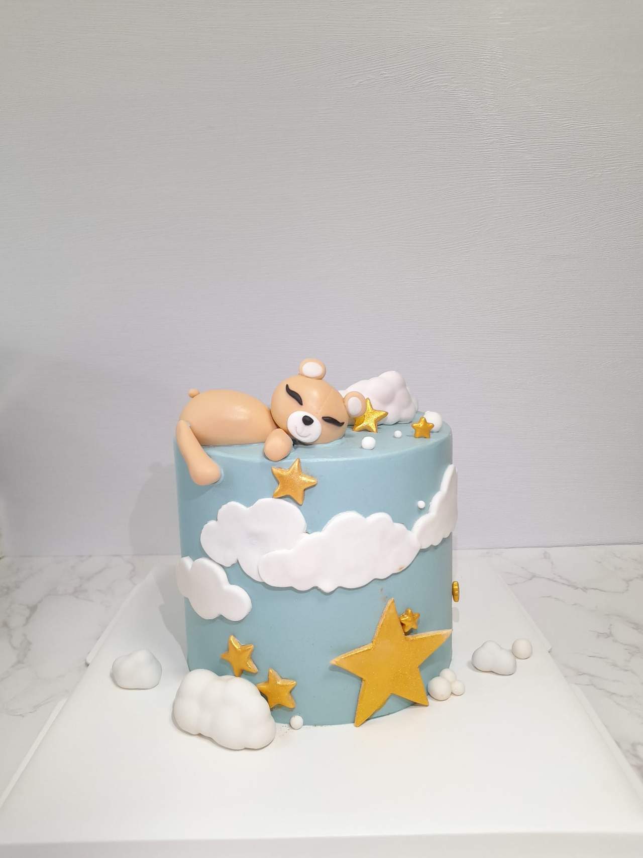 A sleeping-teddy-on-clouds birthday cake, by Bakelicious By Aisha.