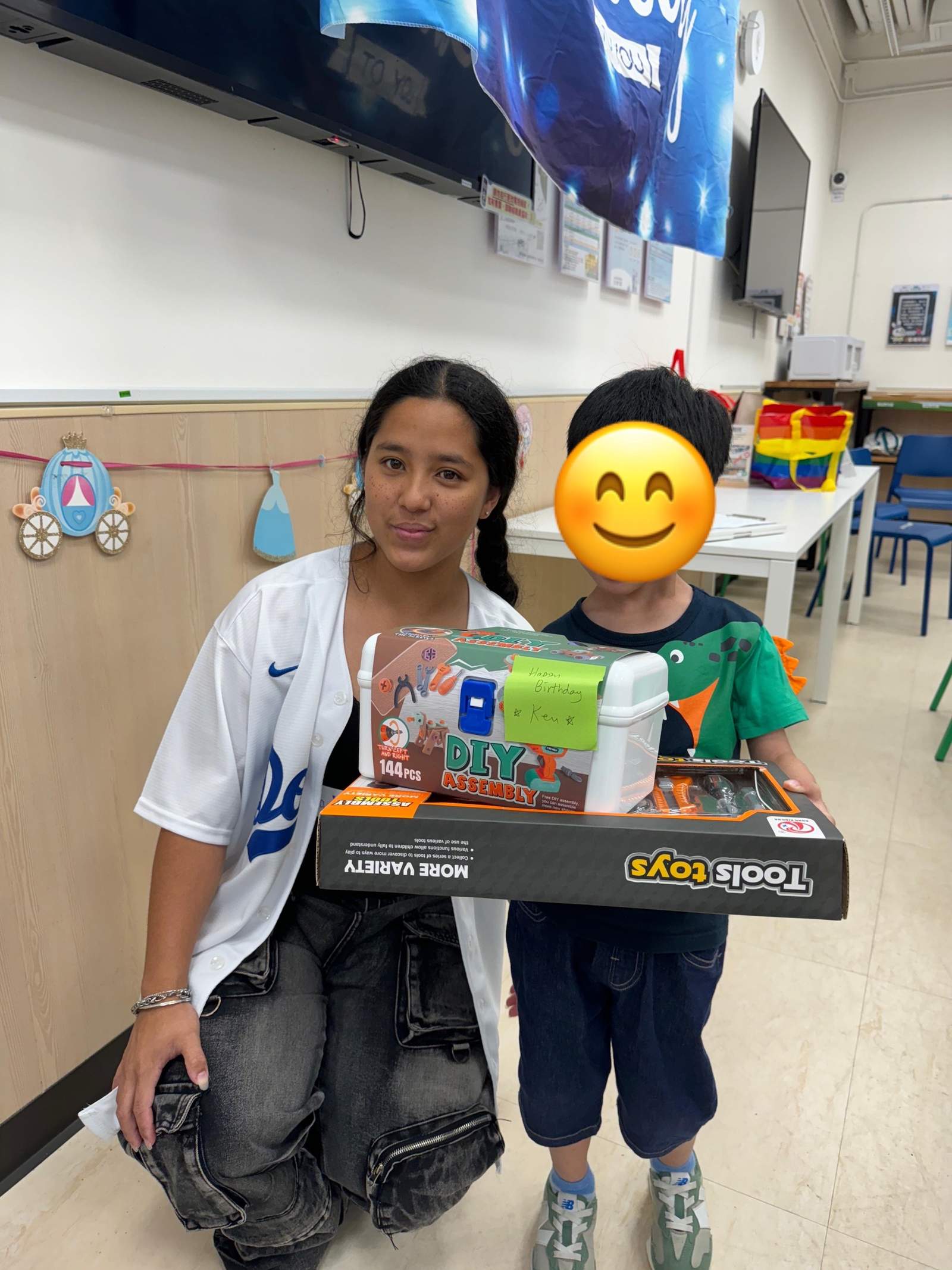 An adult kneels beside a child holding boxed gifts.