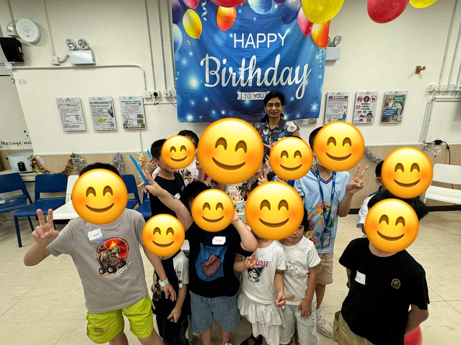 A group of children poses together beneath birthday decorations.