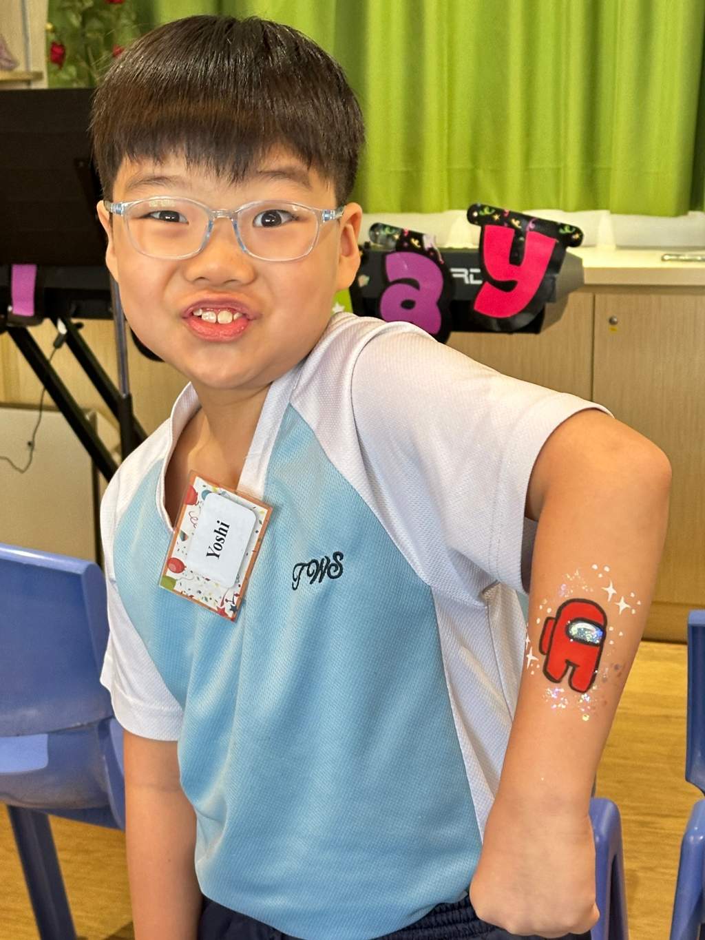 A child displays painted artwork on their forearm.