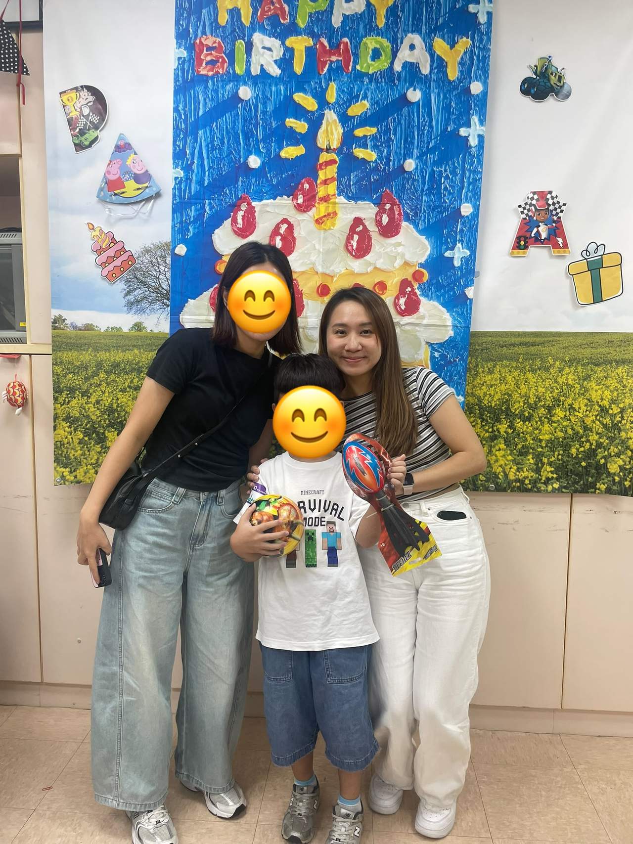 A child holds gifts while posing with two adults.