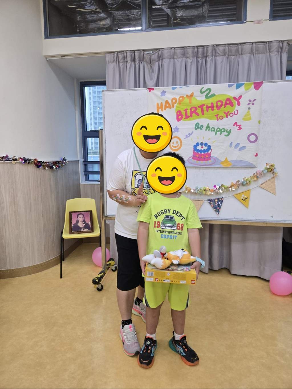 A participant holds a boxed gift and soft toys with a volunteer.