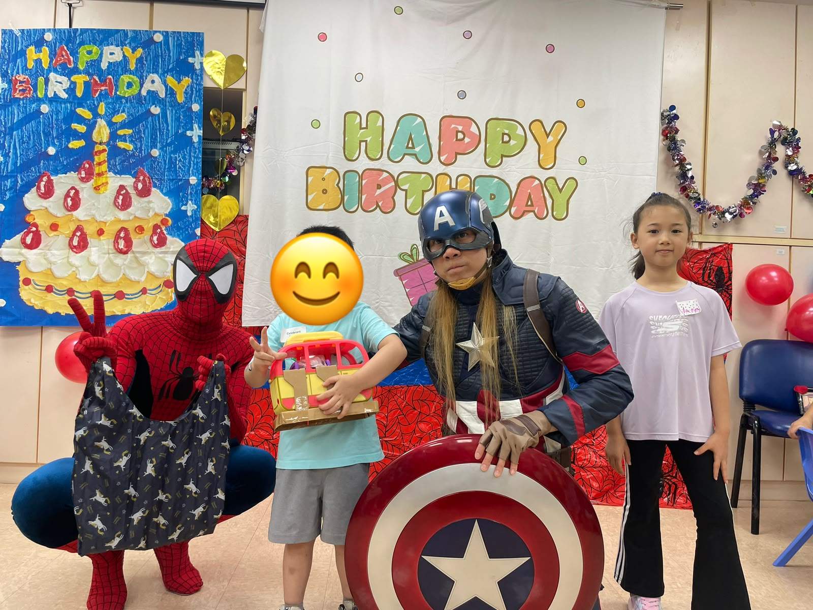 Costumed adults pose with children holding a gift bag and box.