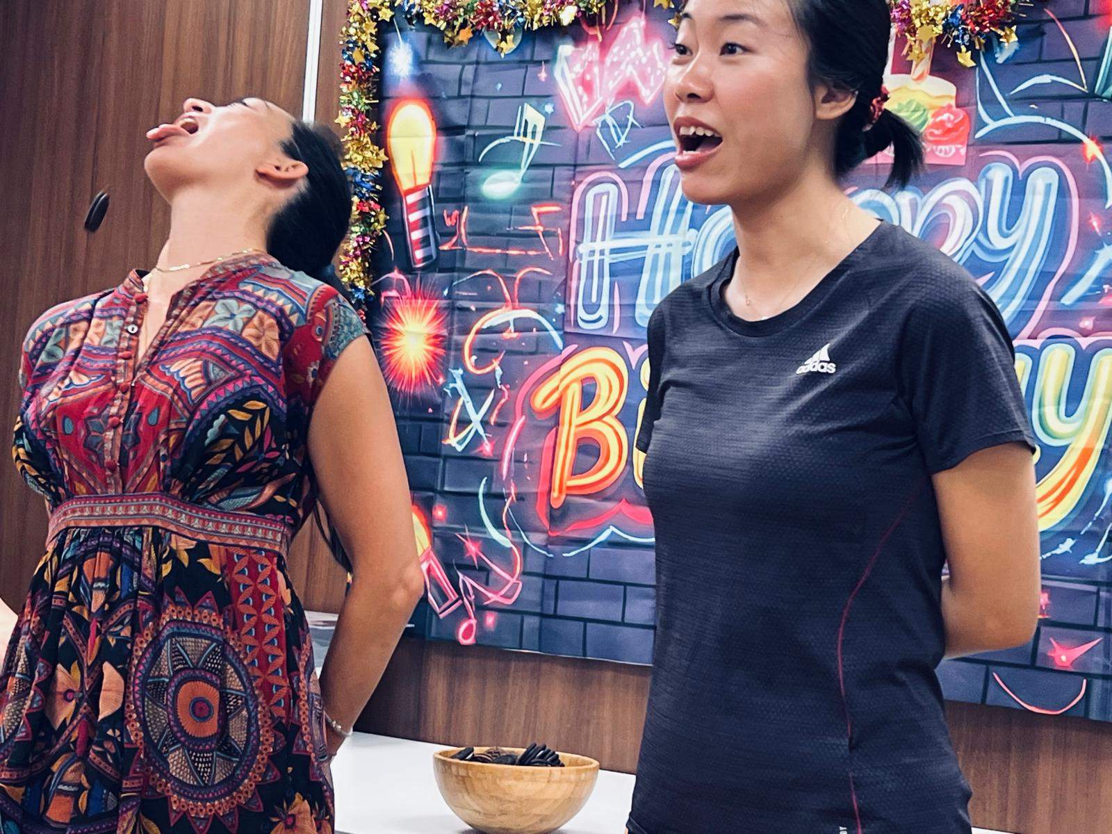 An adult receives face painting beside a birthday backdrop.