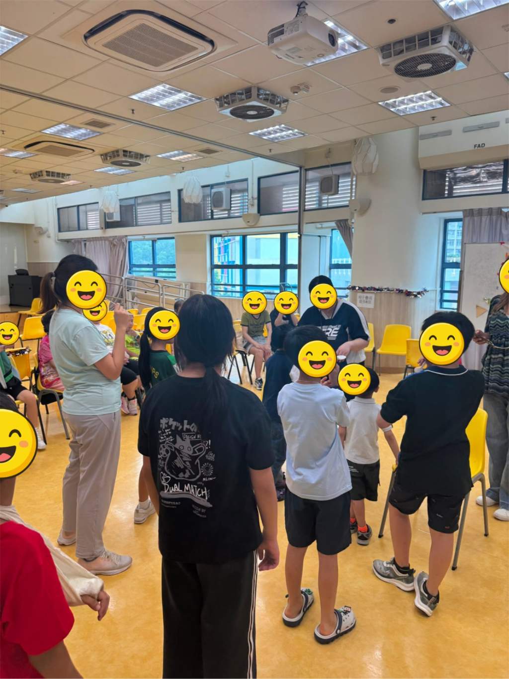 Participants stand in a circle during an indoor party game.