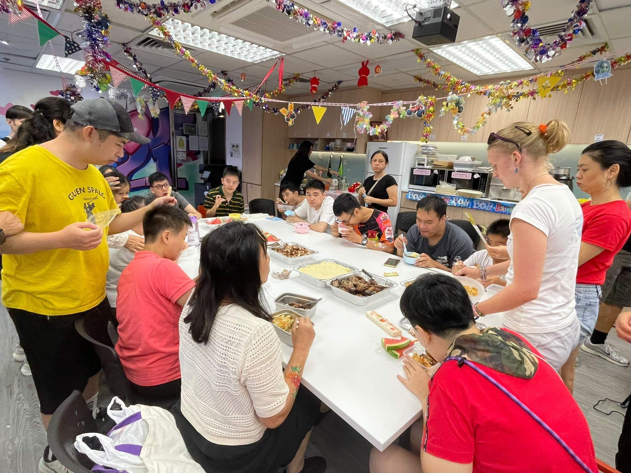 Volunteers assist participants with a shared table activity.