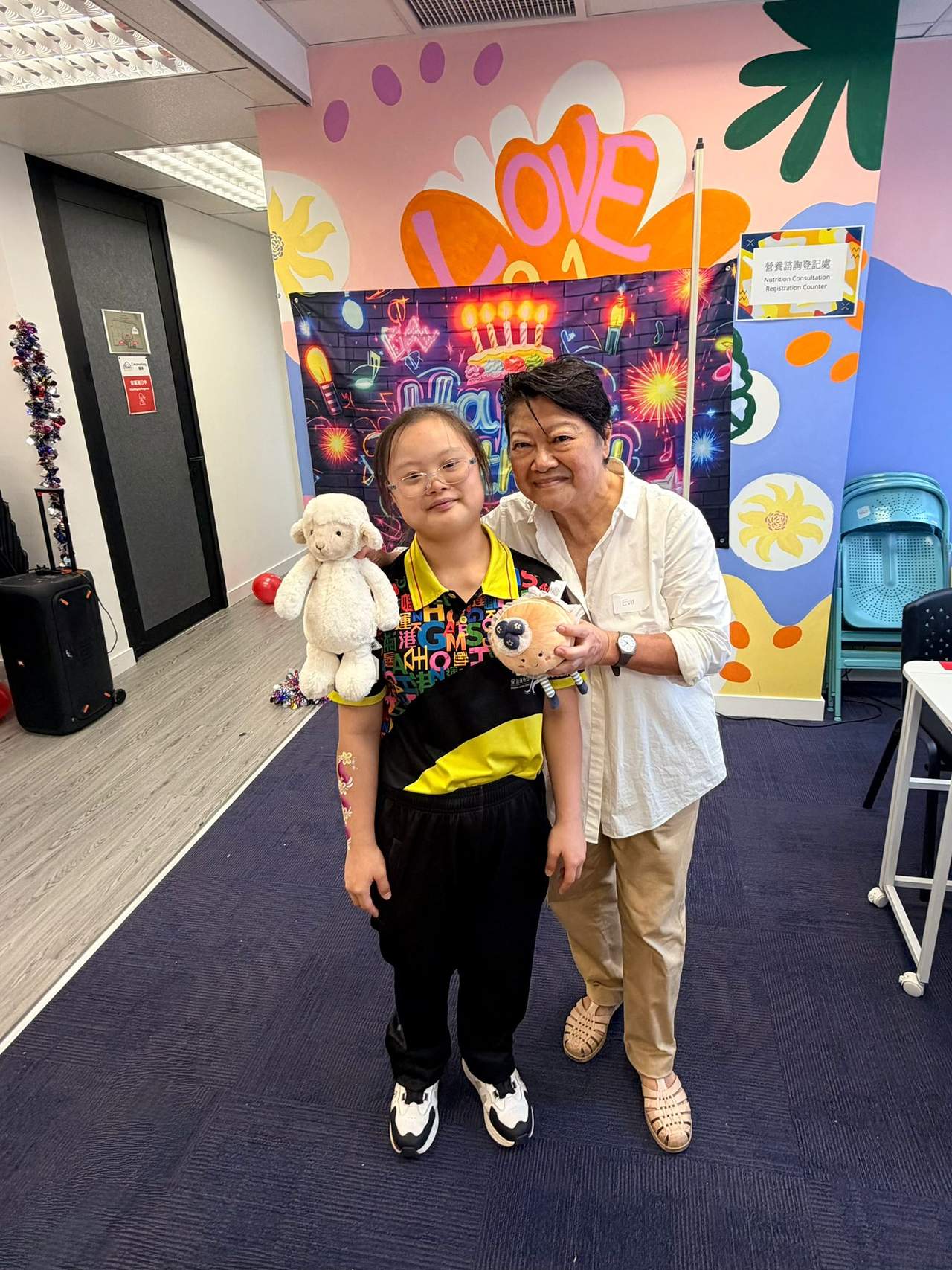 Three people stand together while holding stuffed animals.