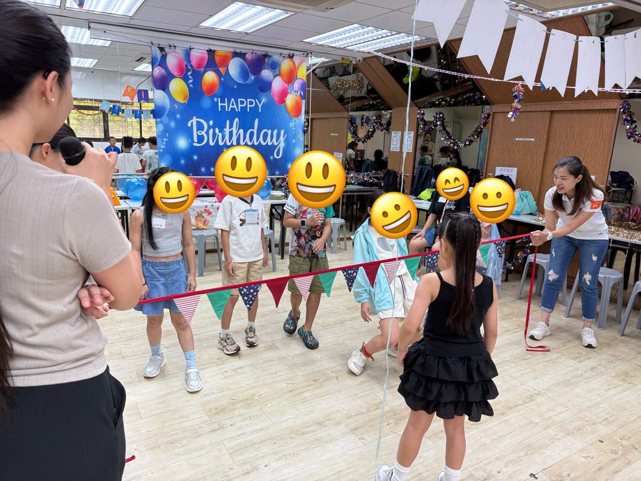A child faces a group holding a bunting strand.