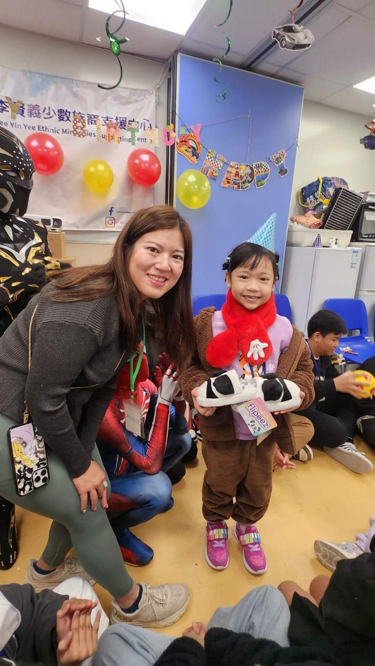 An adult and child pose beside a costumed performer.