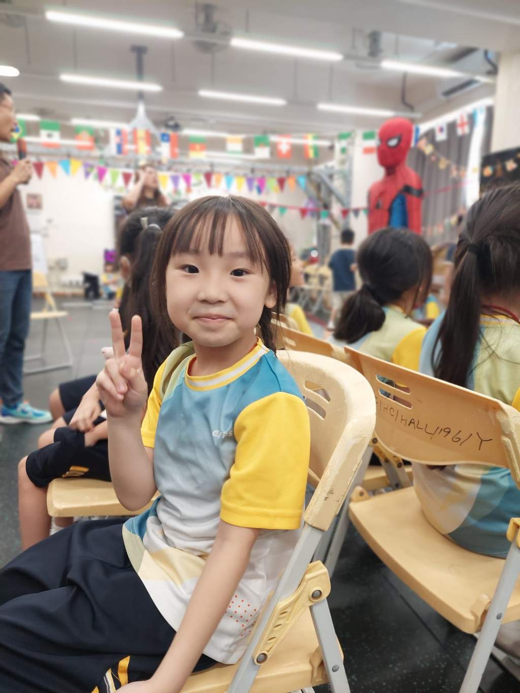 A seated child holds a paper craft for the camera.