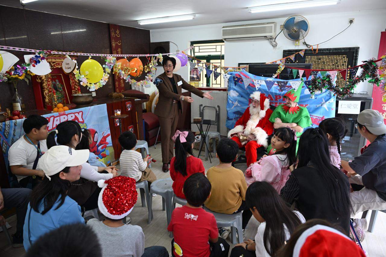 Children and adults watch two costumed performers at the front.