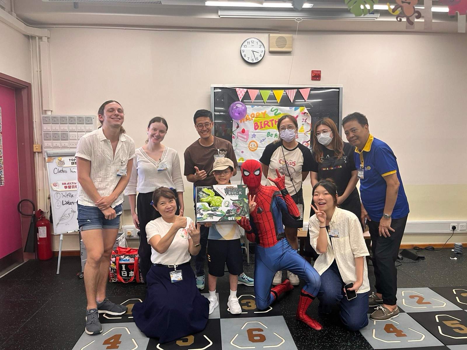 Adults, children, and a costumed performer pose for a group photo.