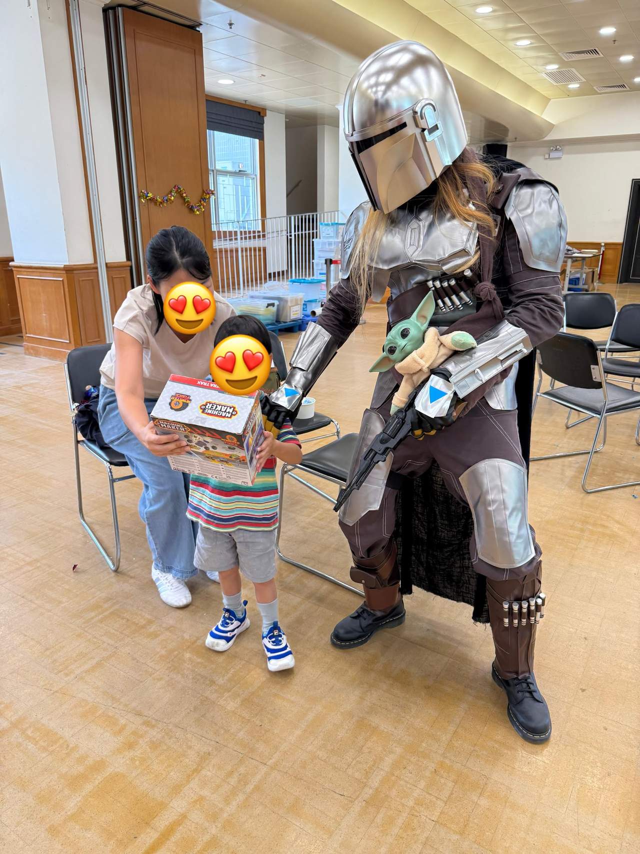 A child receives a boxed gift beside an armored character.